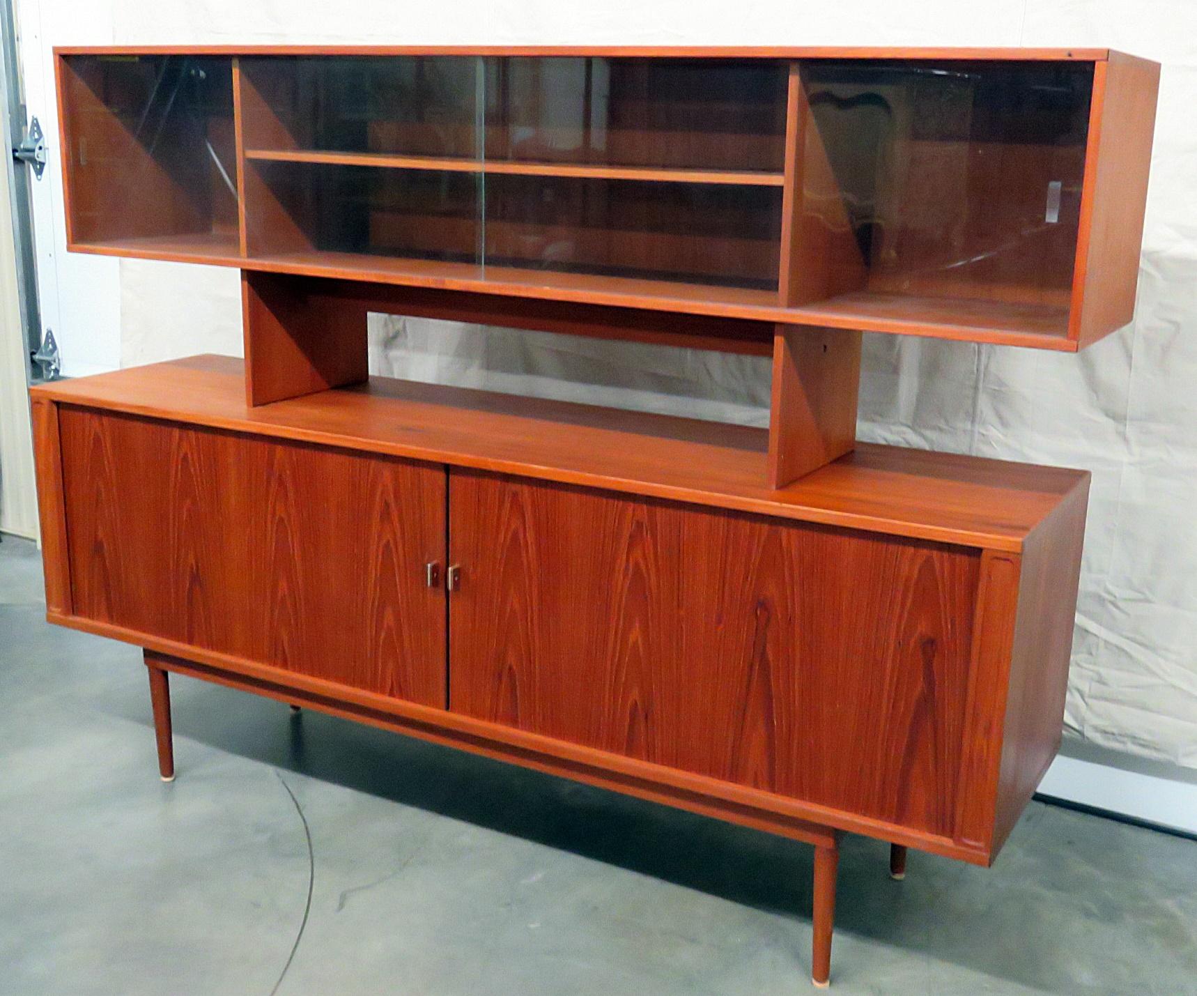 Peter Lovig Nielsen credenza with 2 glass doors on top containing 1 shelf and 2 lower doors containing 2 shelves and 5 drawers.