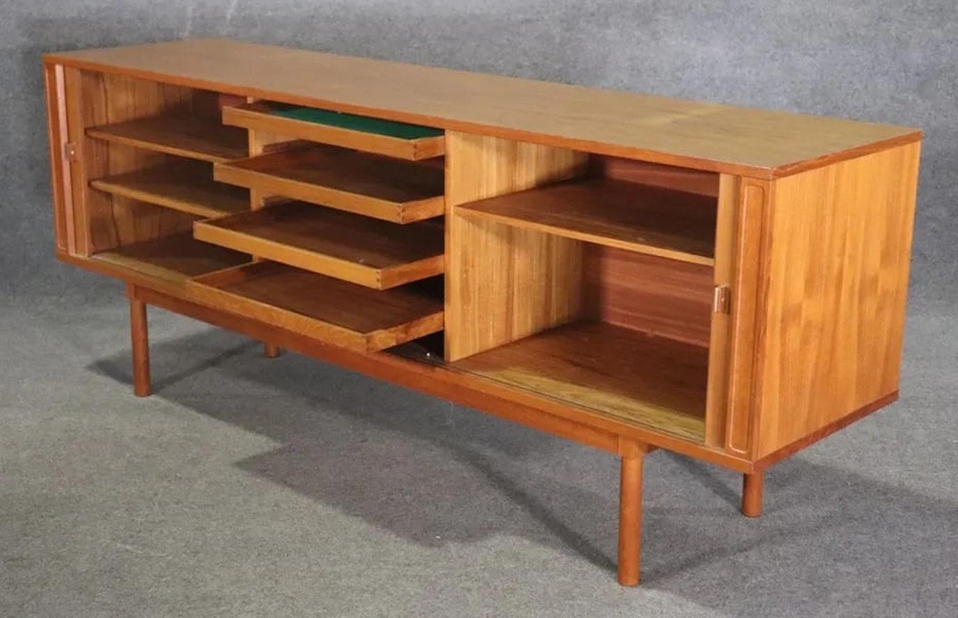 Gorgeous Danish modern sideboard designed by Peter Løvig Nielsen. Handsome design with tambour doors, finished back and warm teak grain throughout.
Please confirm location NY or NJ