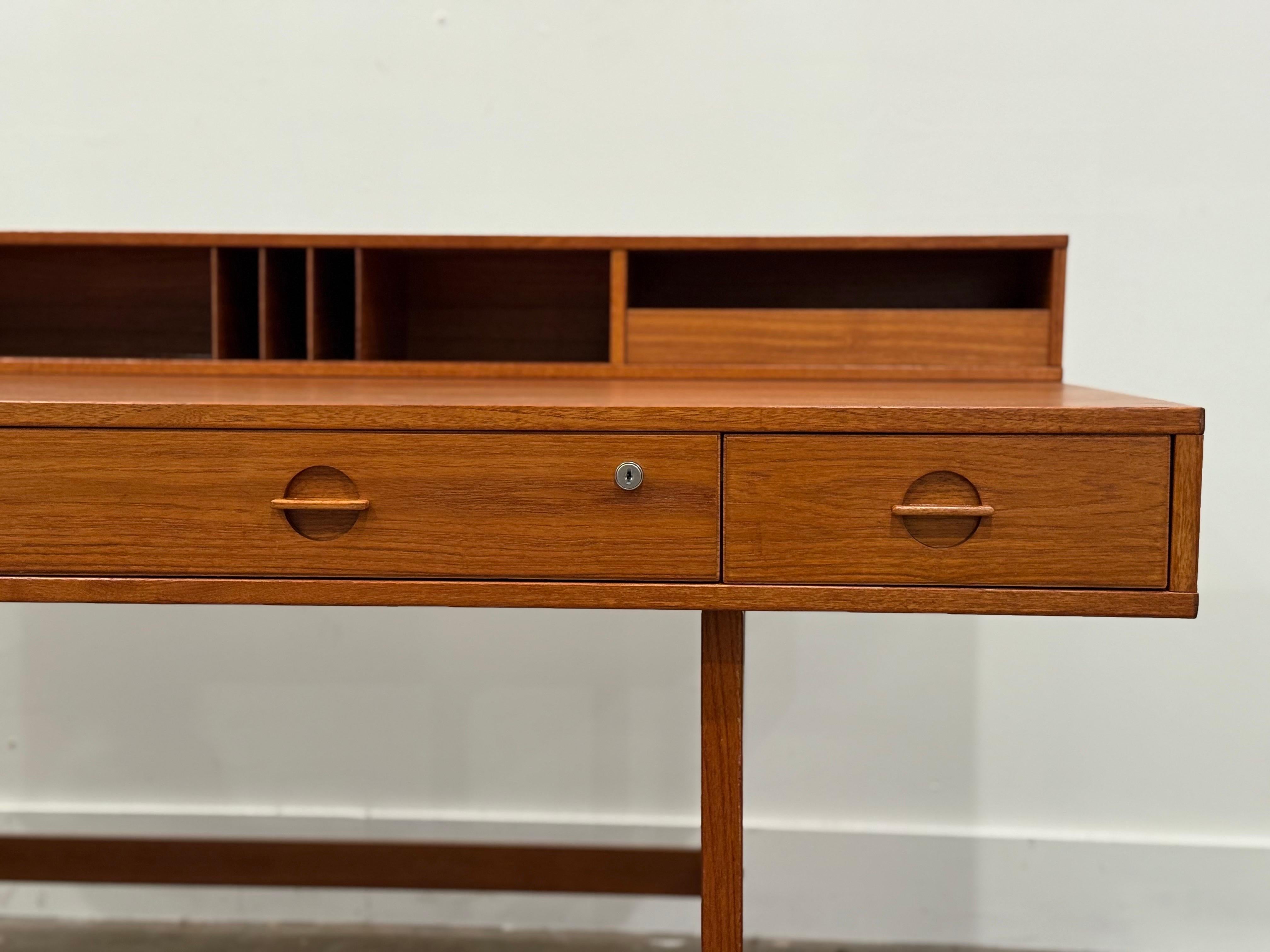 Flip top partner desk by Peter Løvig Nielsen for Lovig Dansk. Gorgeous deep hue old growth teak - built in Denmark circa 1970s. Form, function and versatility. Retains original top tier drawers. Attended to by our team - this desk has been fully