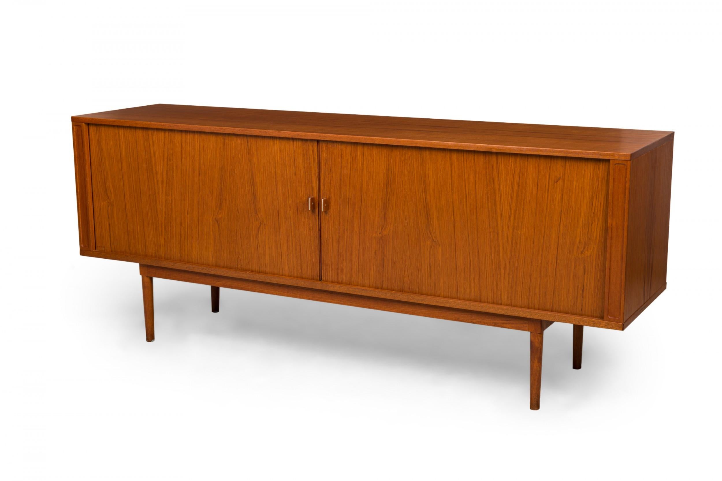 Credenza/armadio rettangolare danese di metà secolo in legno impiallacciato finemente con due ante a tamburo (con tiretti metallici a forma di losanga) che rivelano cinque cassetti centrali estraibili, due scomparti opposti con ripiani regolabili,