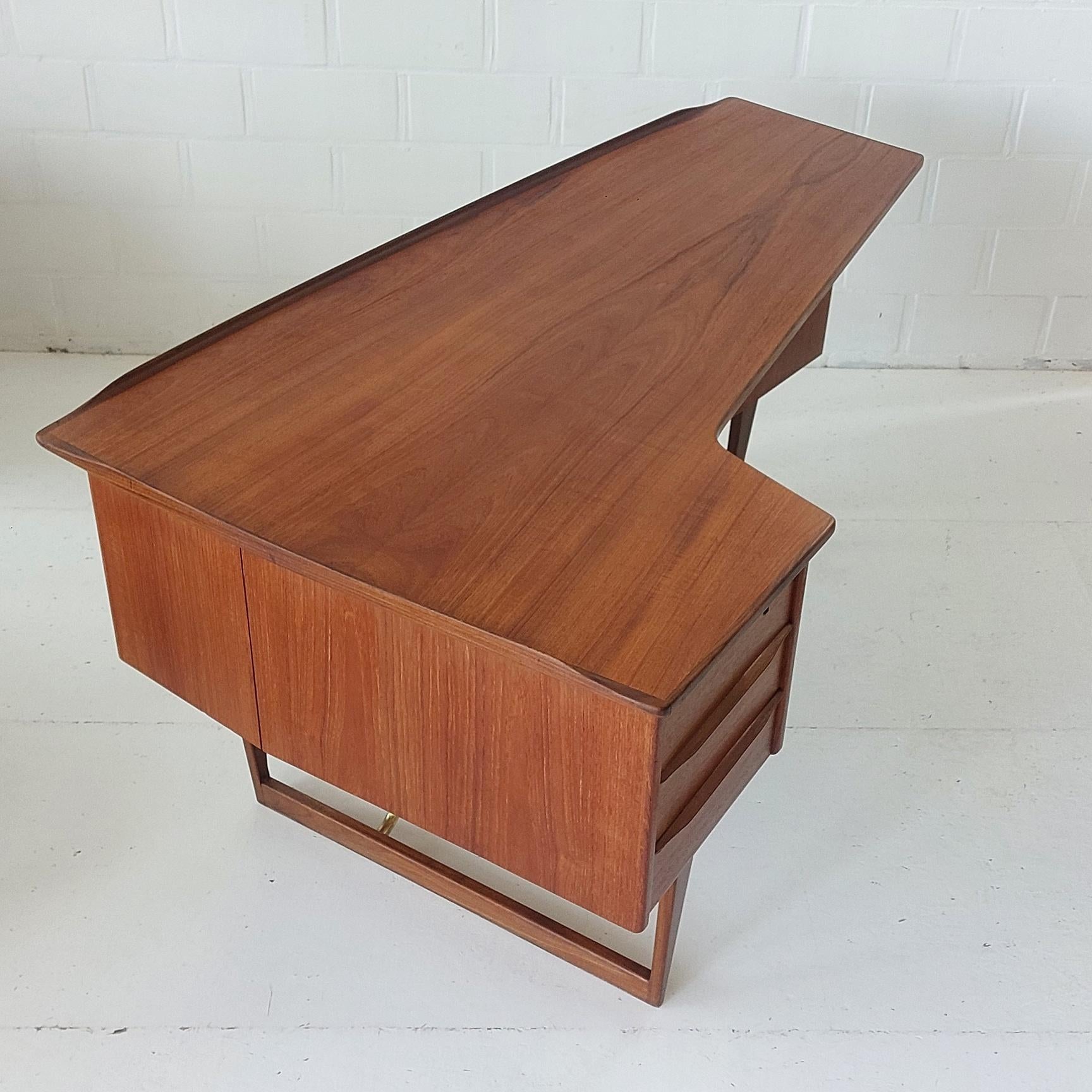 Peter Løvig Nielsen Boomerang Desk + bar 1960s for Lovig Denmark Teak and Brass

Fantastic freestanding boomerang Desk with 3 drawers on the front, on the back there is a lovely small bibliotheque for books and a small tiny hidden bar with a