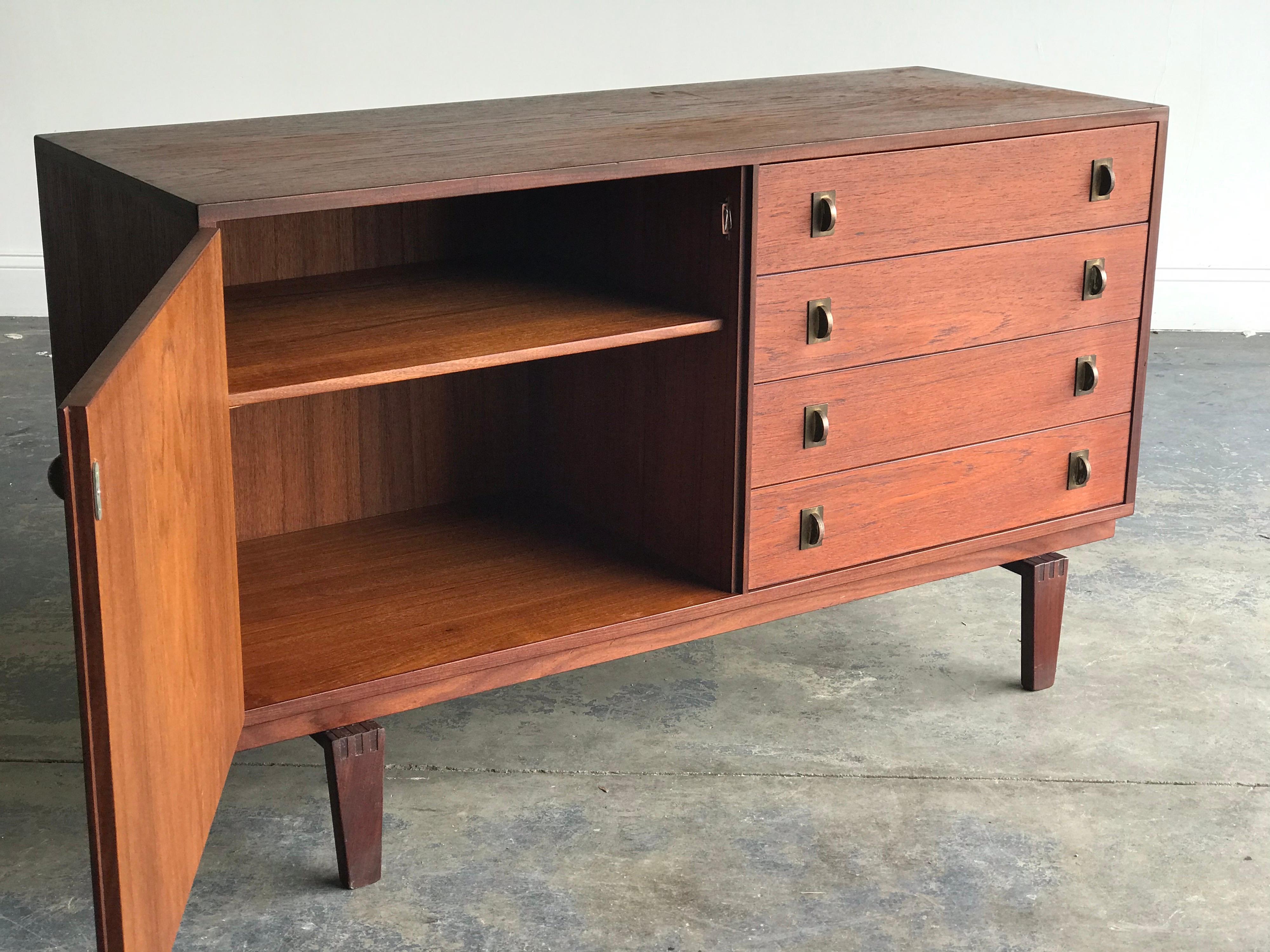 Beautiful petite credenza or sideboard designed by Peter Løvig Nielsen. Four drawers on the right with a door on the left revealing a shelf.