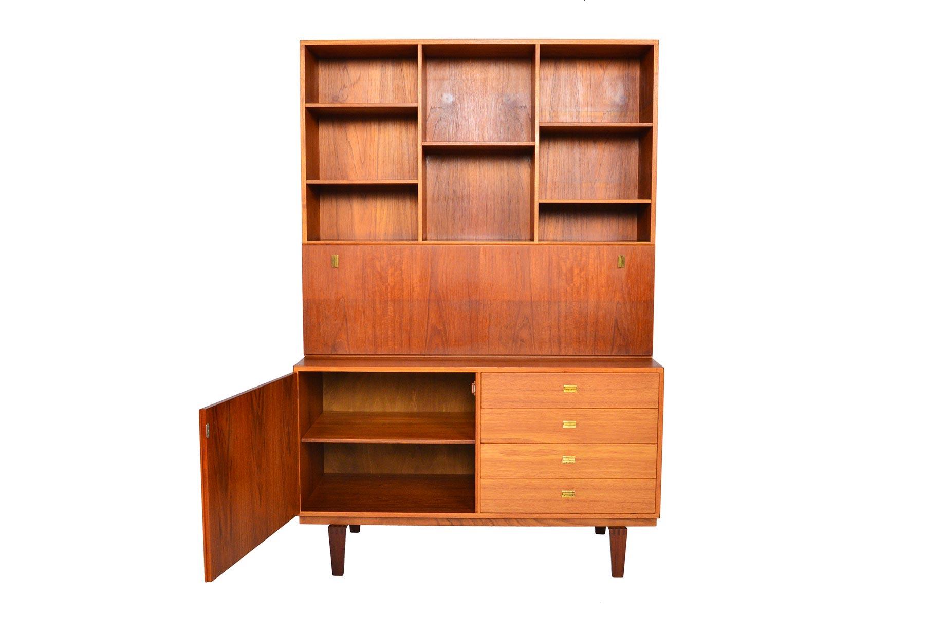This lovely Danish modern teak credenza with hutch by Peter Løvig Nielsen offers a simple sleek design with beautifully patinated original brass hardware. The tall bookcase hutch features a drop down desk surface with three bays and five adjustable