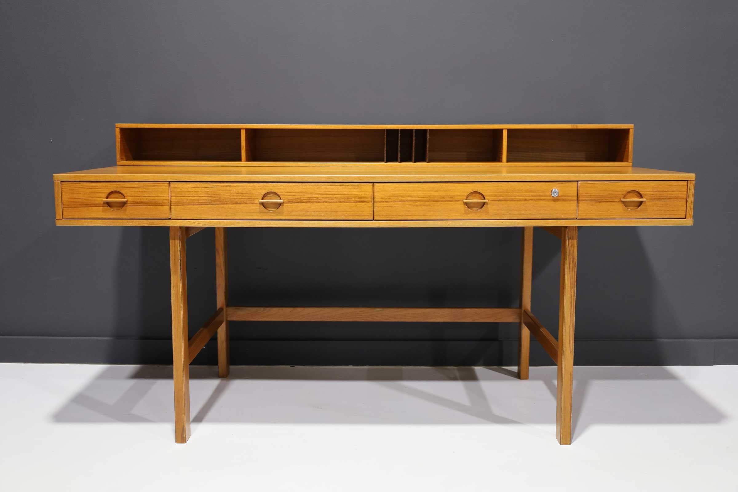Peter Løvig Nielsen flip-top teak desk for Dansk designs.
circa 1970s

Beautifully grained teak with unique flip top shelf flips down to extend the desk for more working space and can be used as a partner’s desk. Restored.

Down:
64