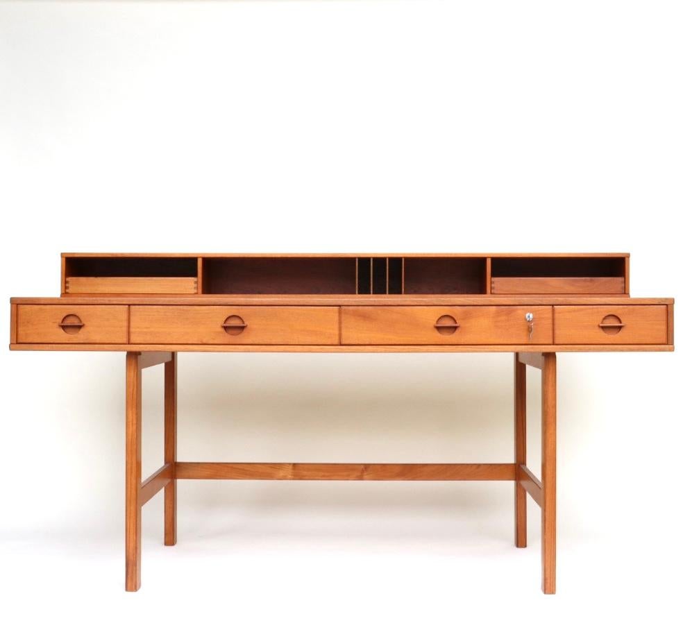 This flip-top partner desk by Peter Løvig Nielsen for Dansk in Denmark has been immaculately restored. It has a gorgeous deep hue, old-growth quarter-sawn teak with beautiful flecks in the wood. Quarter-sawn teak is incredibly strong and means this
