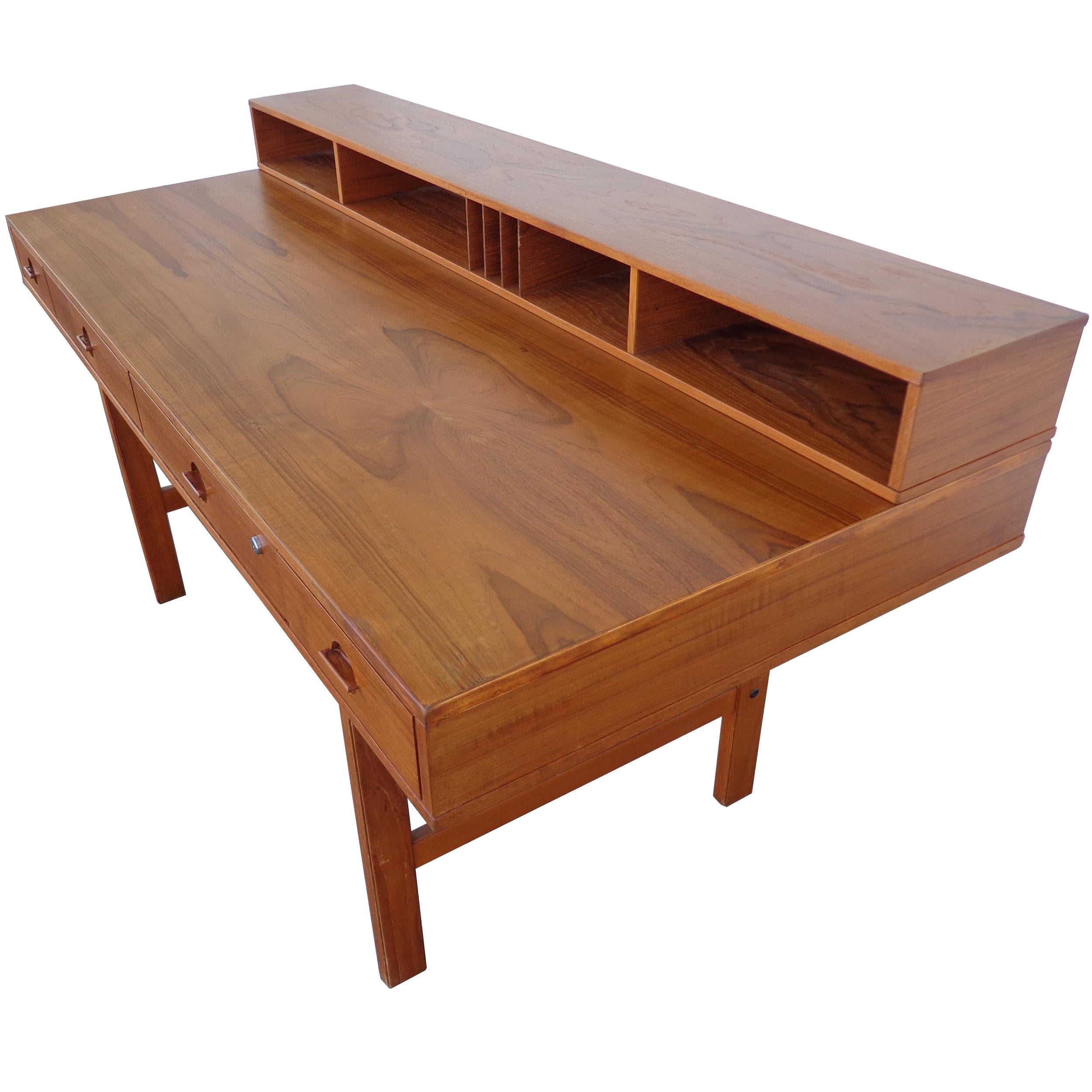 Peter Løvig Nielsen Flip-Top teak desk for Dansk Designs
circa 1970s 

Beautifully grained teak with unique flip top shelf flips down to extend the desk for more working space and can be used as a partner’s desk. Restored.

Down:
64? Width x