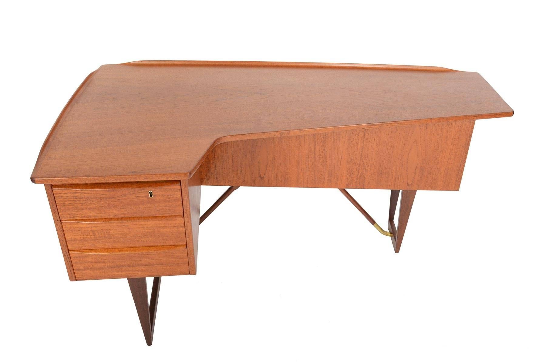 This rare and wonderful Danish modern biomorphic boomerang desk in teak was designed in 1956 by Peter Løvig Nielsen for Hedendsted Møbelindustri. A marvel from every angle, this hallmark piece features a left oriented bank of three drawers. The back