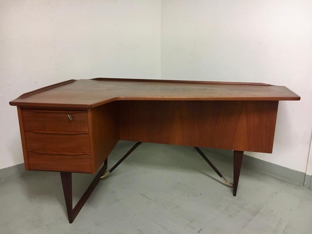 Boomerang teak & brass desk by Peter Løvig Nielsen produced by Hedensted Møbelfabrik, Denmark 1968
3 frond drawers, 1 bar cabinet at the back, with key.
Beautiful legs with brass details.
Dated 1968 under one drawer.
Perfect condition, never