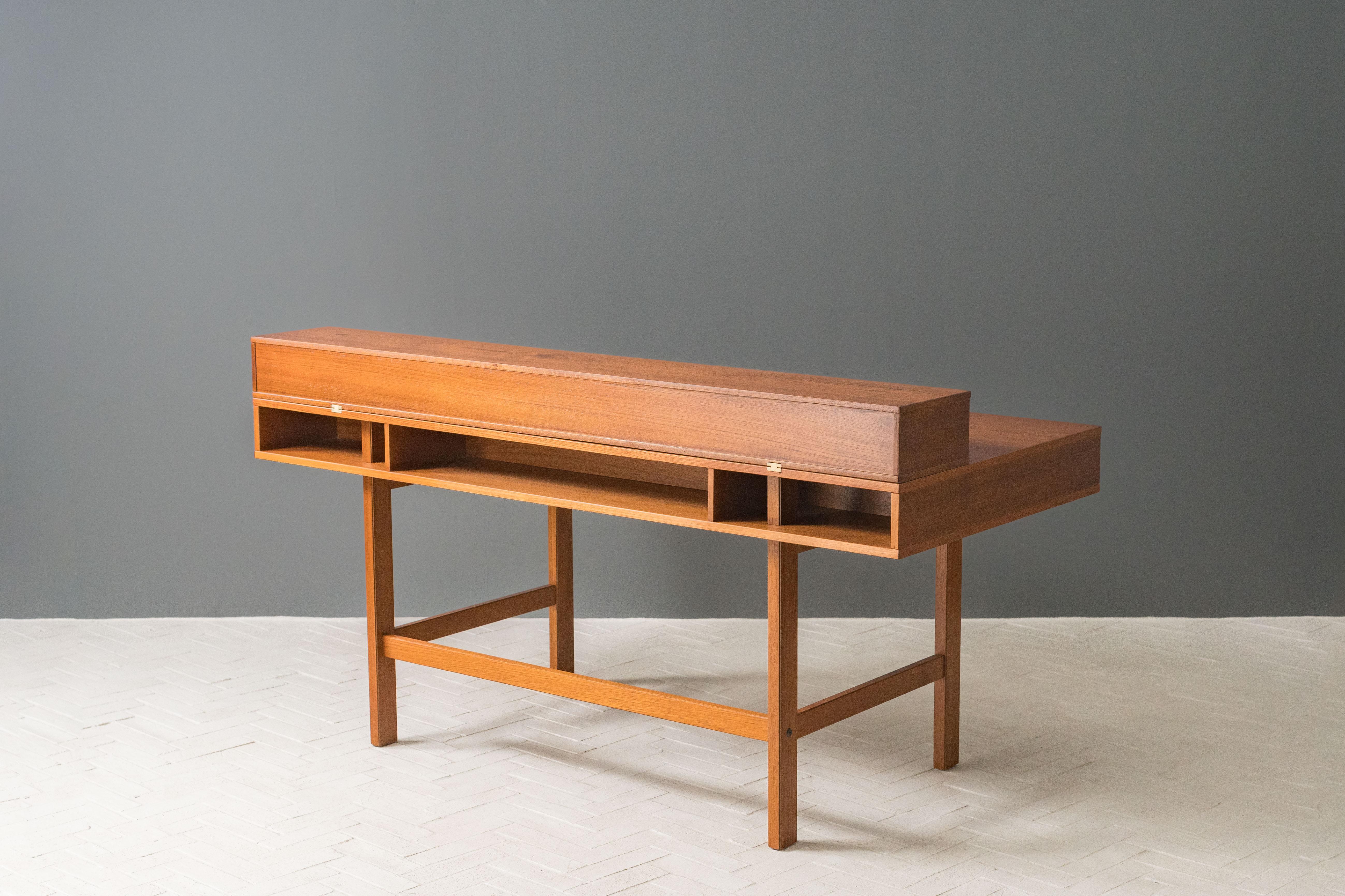 Denmark, ca. 1960s. A handsome teak flip-top partners desk by Peter Løvig Nielsen for Løvig. Features nicely grained teak construction with four drawers and a hinged flip-top gallery, converting from a writing desk to a well sized partners desk or