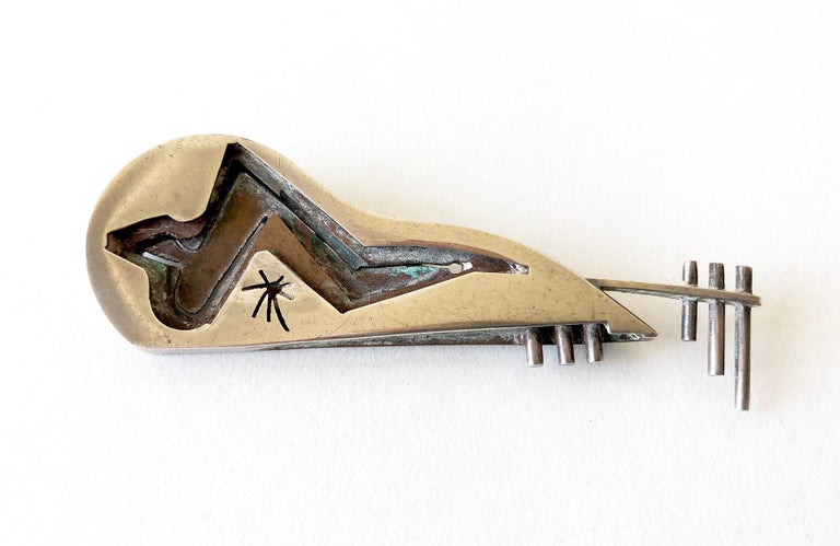 Late 1940's American abstract modernist bass or stringed instrument guitar brooch created by Peter Macchiarini of San Francisco, California.  Brooch consists of layers of oxidized copper and sterling silver with pierced design and measures 3.5