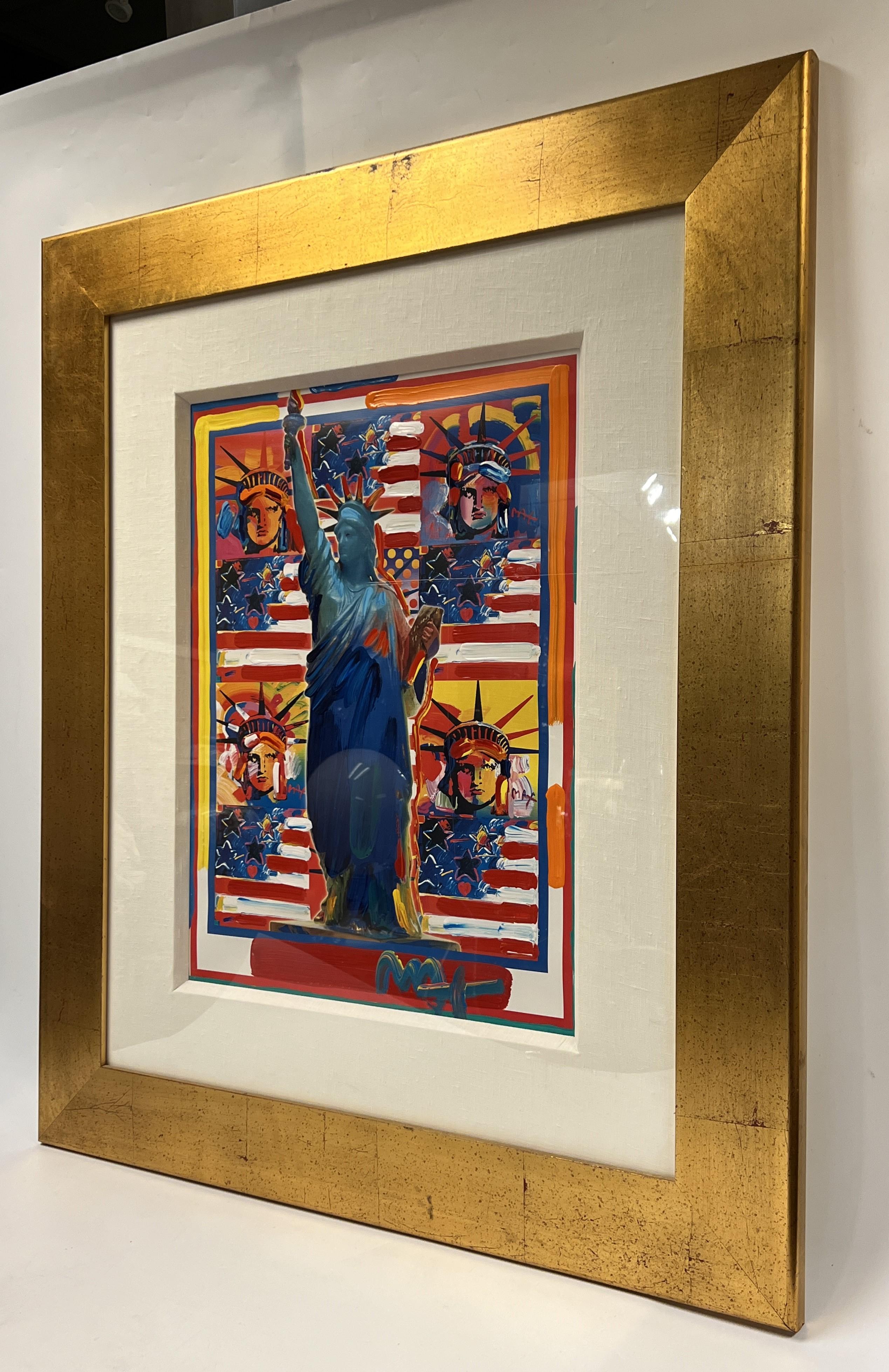 Mixed media acrylic painting known as God Bless America with Five Liberties by Peter Max in its original plexiglass glazed wooden frame with linen matte and gold leaf finish.  Frame 33 by 39 by 1 inch. Portion of the painting visible 17 by 33