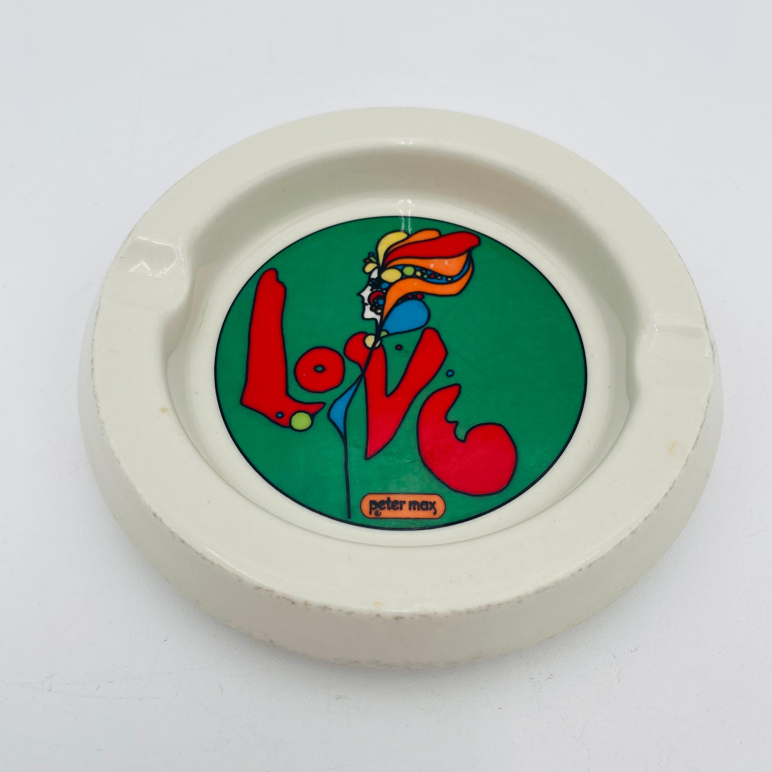 I colori ricchi e vivaci del verde, del rosso, dell'arancione e del giallo adornano questo posacenere 