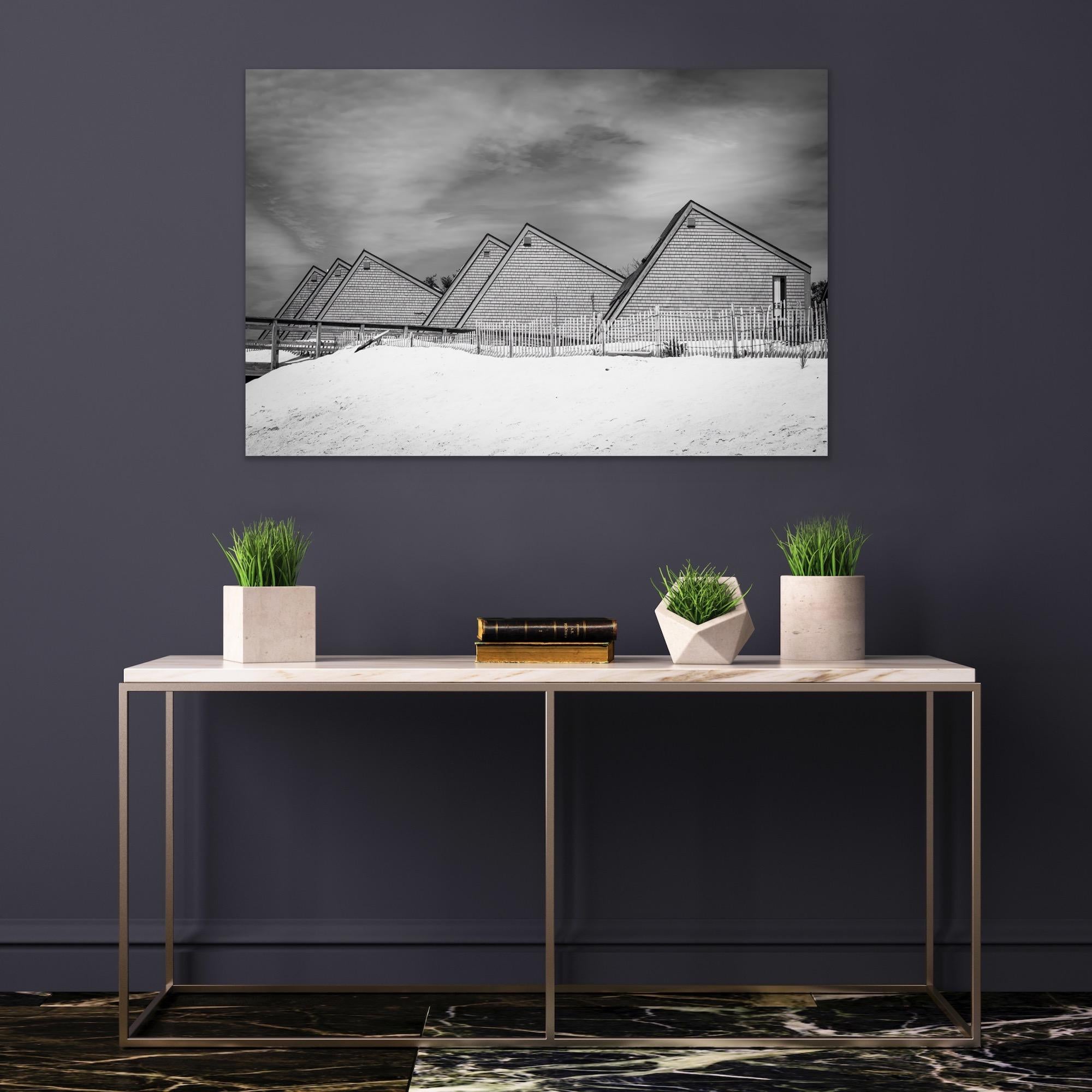 This contemporary black and white architectural photo captures triangular coastal homes, lined up next to one another a New England beach shore. 

This is a metal sublimation print. The frame on an aluminum print is flush with the edge of the print,