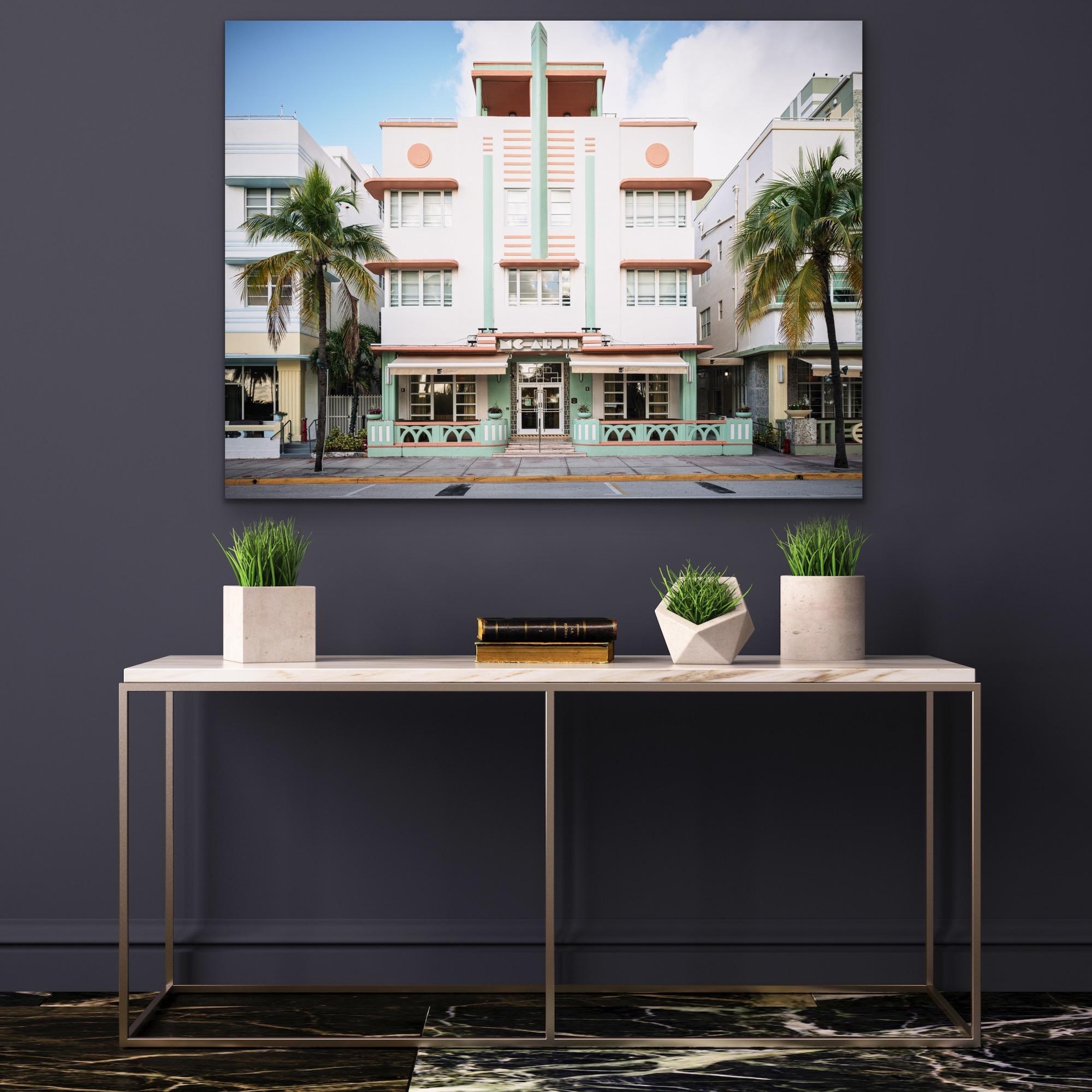 This contemporary urban photograph by Peter Mendelson captures the Deco style MC Alpin building in Miami Beach, Florida, with palm trees and neighboring Deco style buildings on either side. 

This is a metal sublimation print. The frame on an
