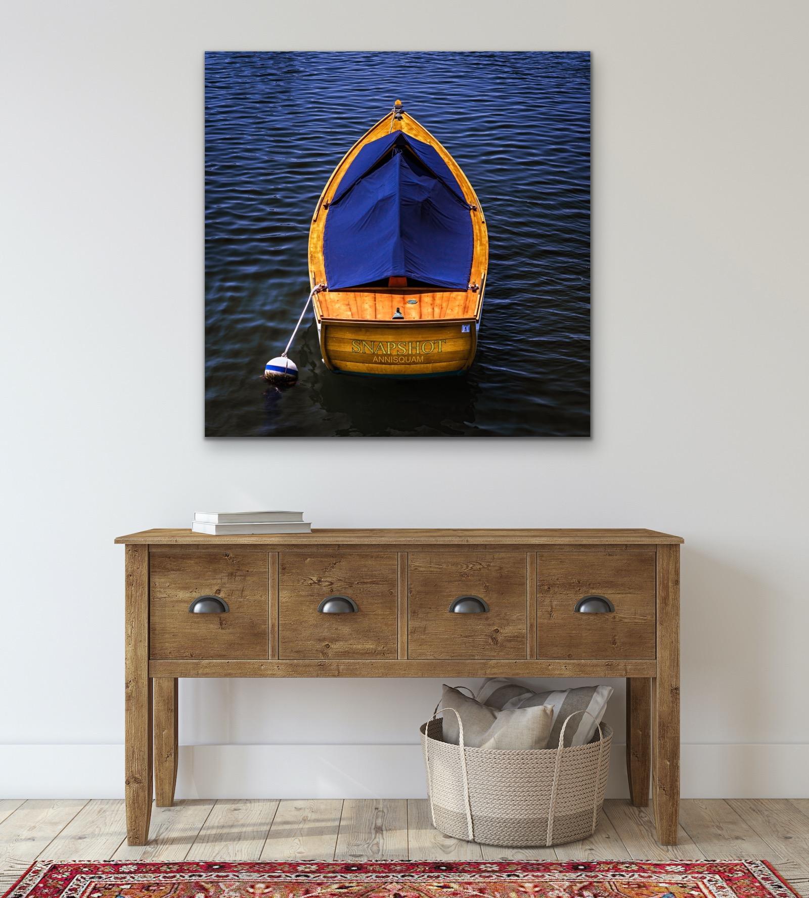 This contemporary nautical photograph by Peter Mendelson captures a vibrant yellow-toned row boat, anchored in contrasting deep blue water. 

This is a metal sublimation print. The frame on an aluminum print is flush with the edge of the print,