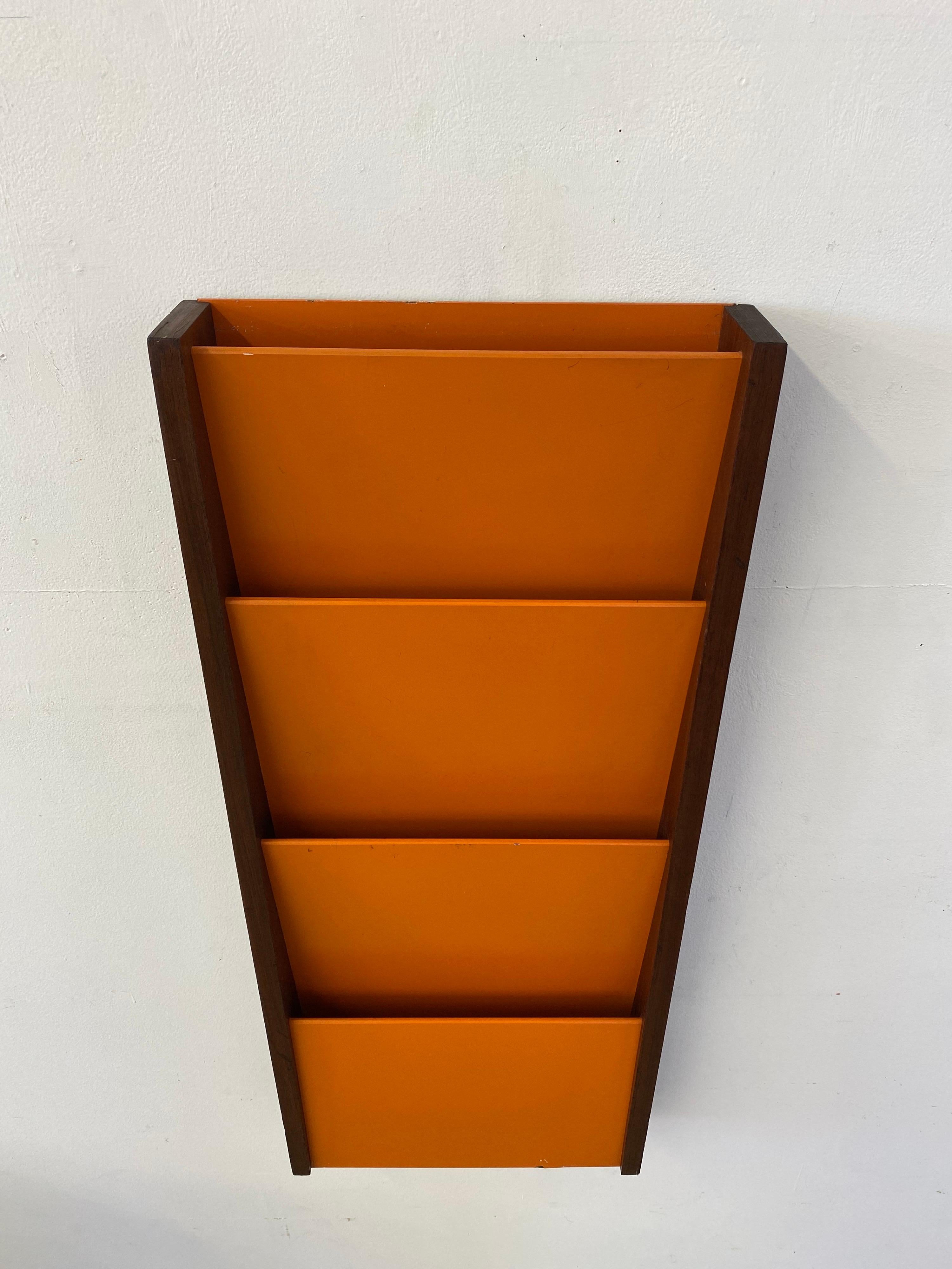 Peter Pepper product walnut and orange painted Masonite wall magazine rack. Great color combo! All original condition. Couple spots of paint loss and broken edge to back bottom as seen in photos. From the front you don't see the torn piece of