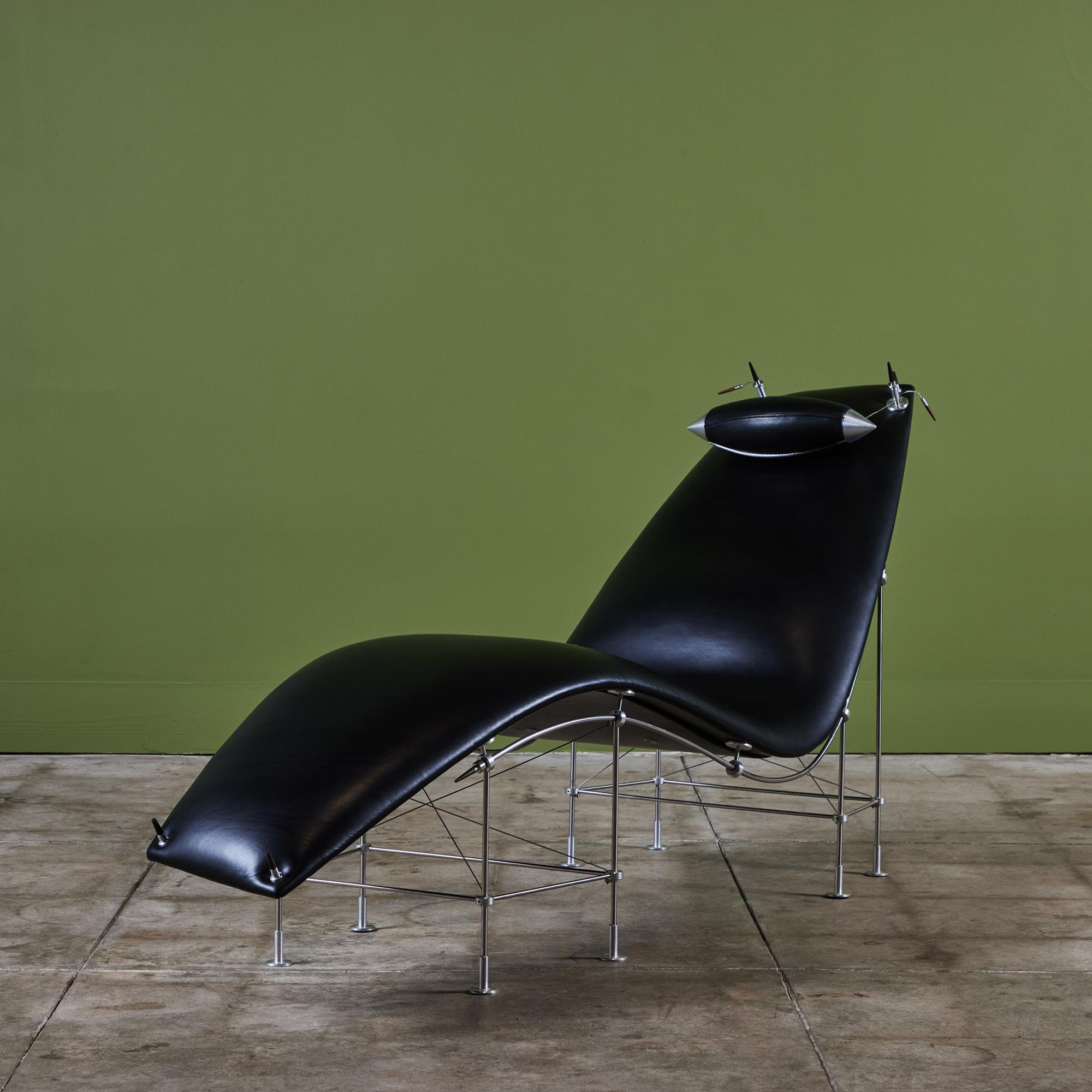 Del diseñador australiano Peter Prasil, una exclusiva tumbona de cuero. La chaise presenta un curvilíneo asiento tapizado en cuero negro que se apoya en un armazón tubular de aluminio similar a un andamio. La juguetona chaise asimétrica tiene un