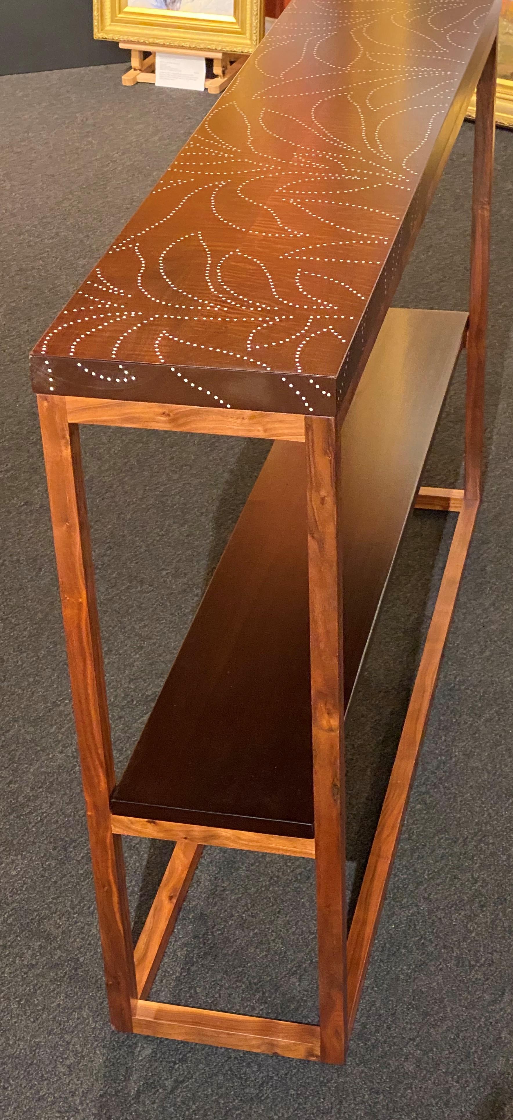 A fine custom contemporary console with medial shelf in walnut and thermally modified maple with a simple inlaid foliate aluminum nail design by artist and furniture maker Peter Sandback. Sandback has gained a national reputation for his intricate