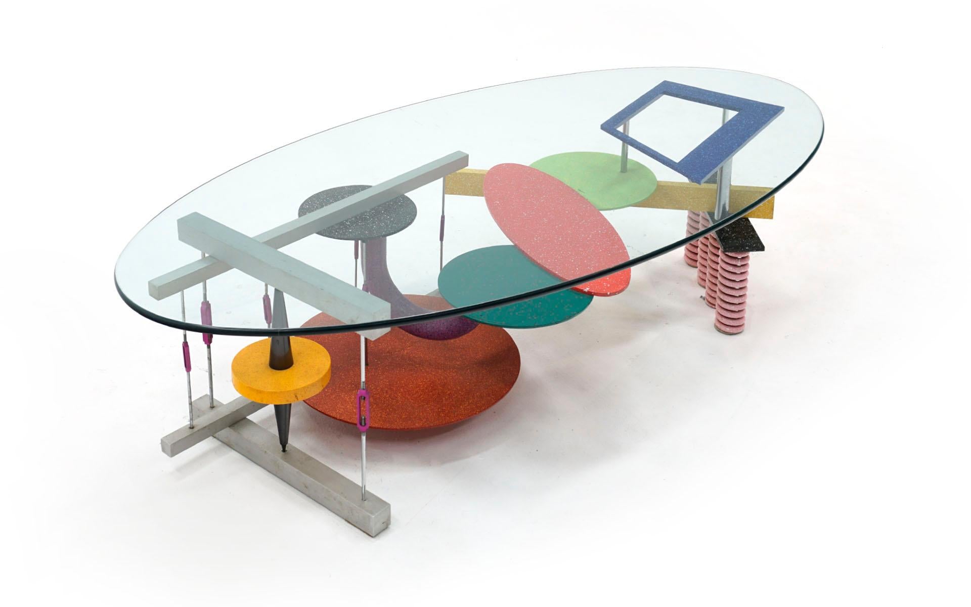 Post Modern coffee table by Peter Shire, Los Angeles, early 1980s. Multi color enameled steel and aluminum base with the original oval glass top. No chips or significant scratches to the top. The base is in very good condition with few if any signs