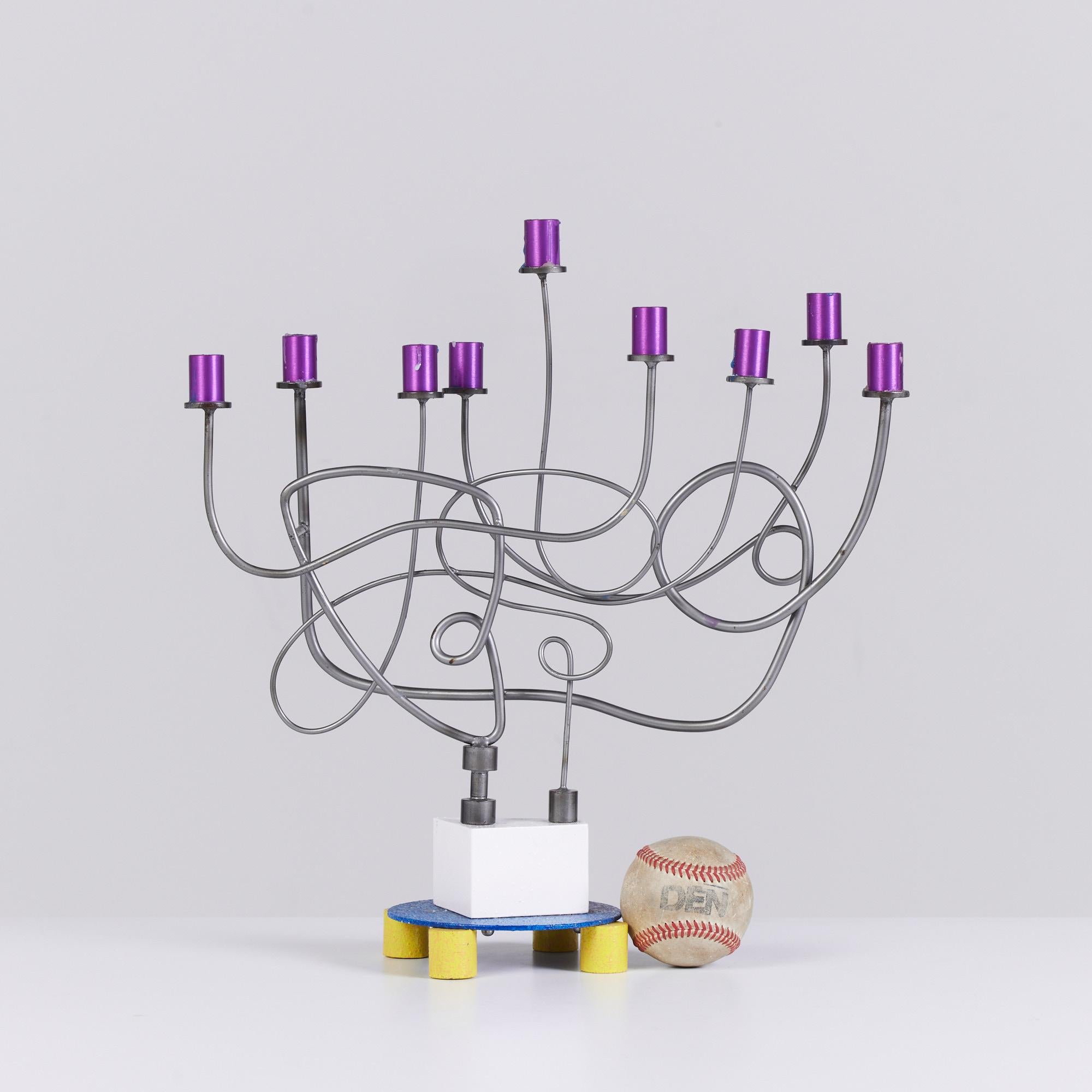 Sculptural Menorah designed by Los Angeles artist Peter Shire, c.1990s. This piece is whimsical in design with its winding metal candle holders. The pop art menorah showcases bright colors of blue, yellow and purple.

Dimensions: 14.5?