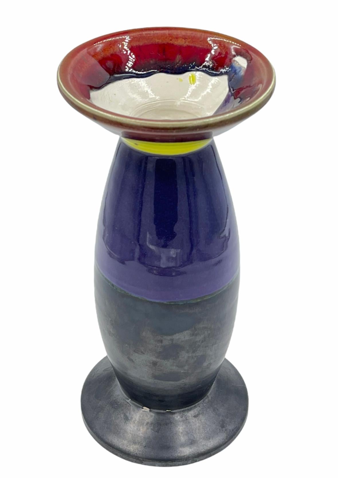 Tall expo vase 2000 in colors of purple yellow brown and gun metal black. Peter Shire, a founding member of Sottsass' Memphis Milano Group is an LA-based artist whose work eludes all attempts at categorization. He has created ceramics, furniture,
