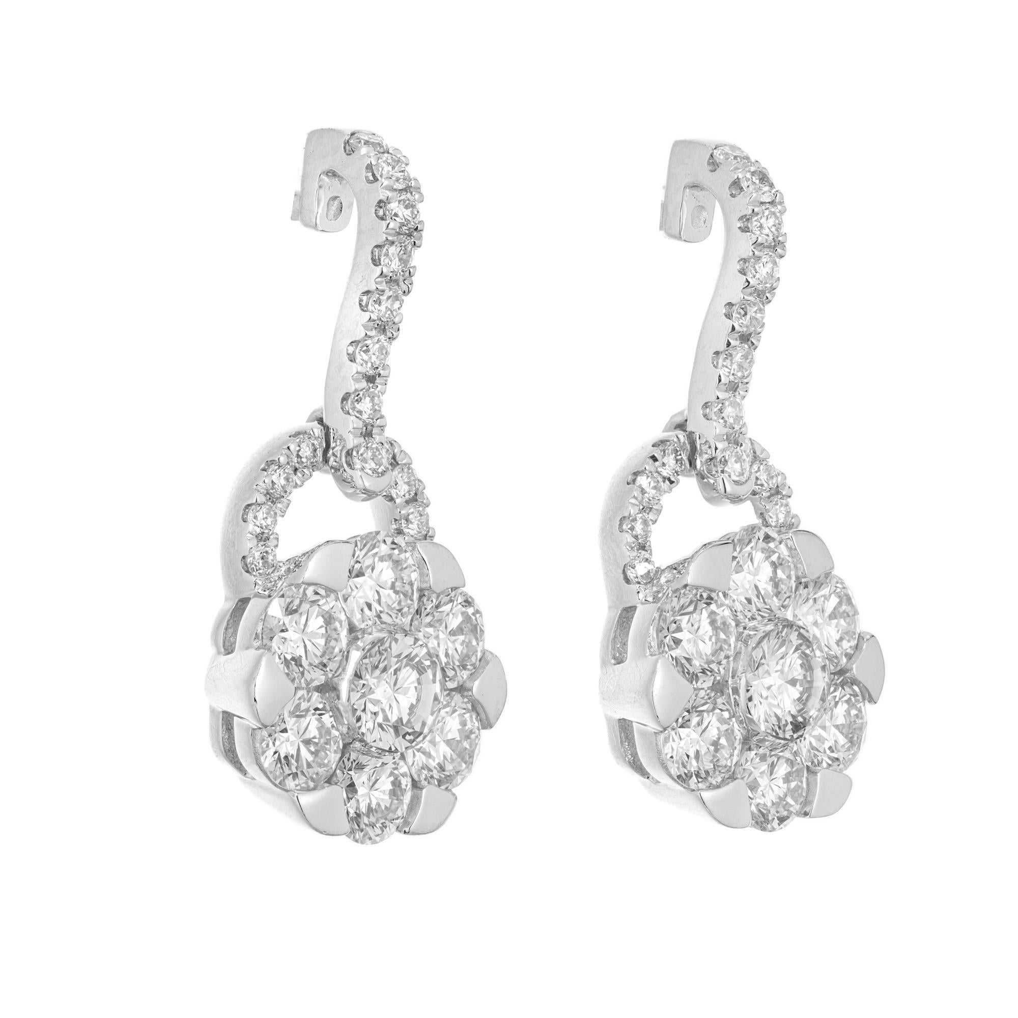 Diamond dangle earrings. 46 round brilliant cut diamonds totaling 1.00cts, set in 14k white gold settings. Two flower designed dangles each with seven round cut diamonds with a half diamond hoop that is connected to a diamond hinge. Designed and