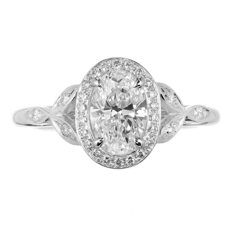 Anello di fidanzamento con diamante ovale aureolato. Design di ispirazione vintage. Diamante ovale centrale certificato GIA extra luminoso e scintillante in un'incastonatura in platino con accenti di diamanti laterali. Uno stile semplice e classico,