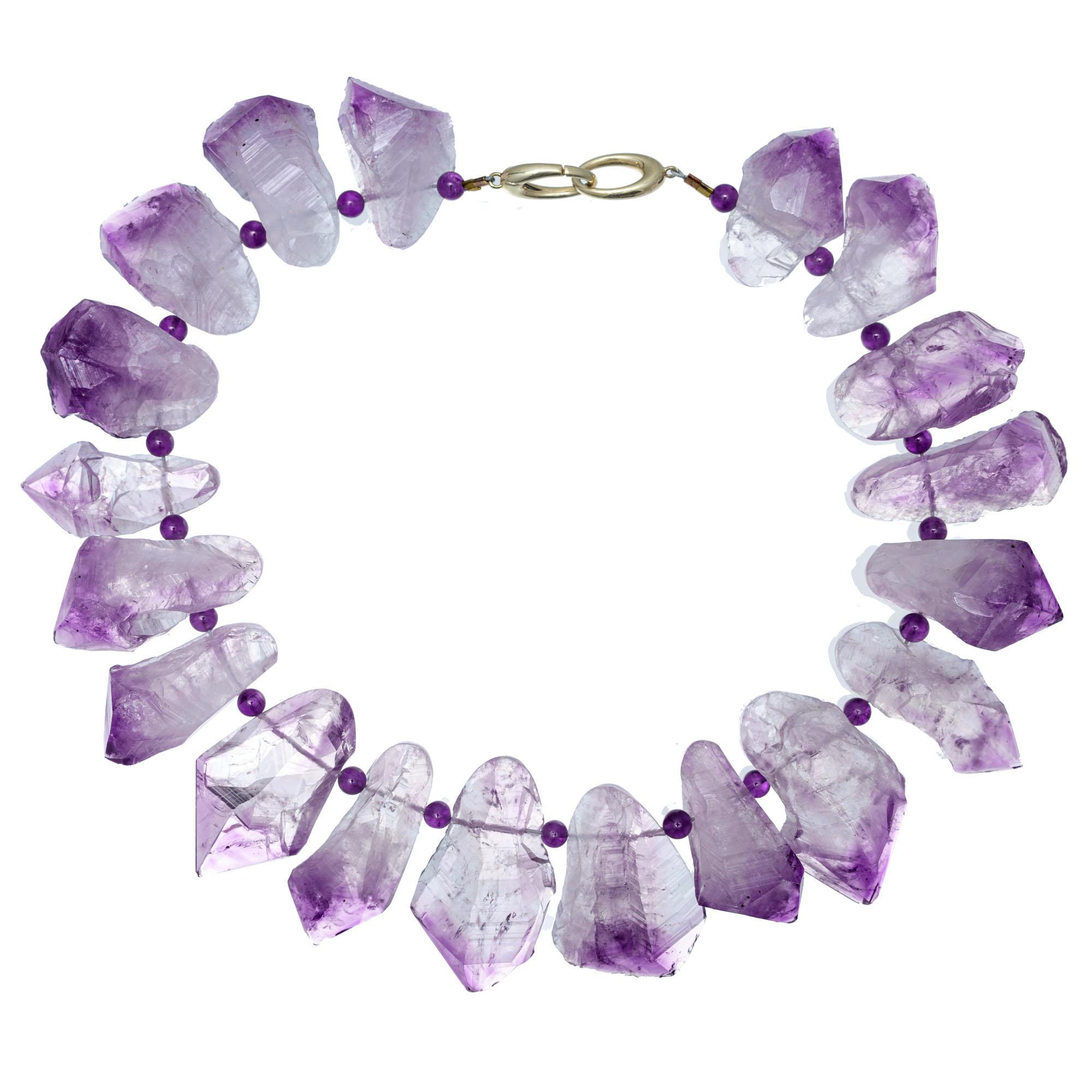 Natural amethyst in Quartz, natural shape with flattened backs. Drilled and strung into a substantial one of a kind necklace. Genuine Amethyst spacers. Heavy Tiger Tail wire, 14k yellow gold clasp. The Quartz has natural inclusions. Created in the