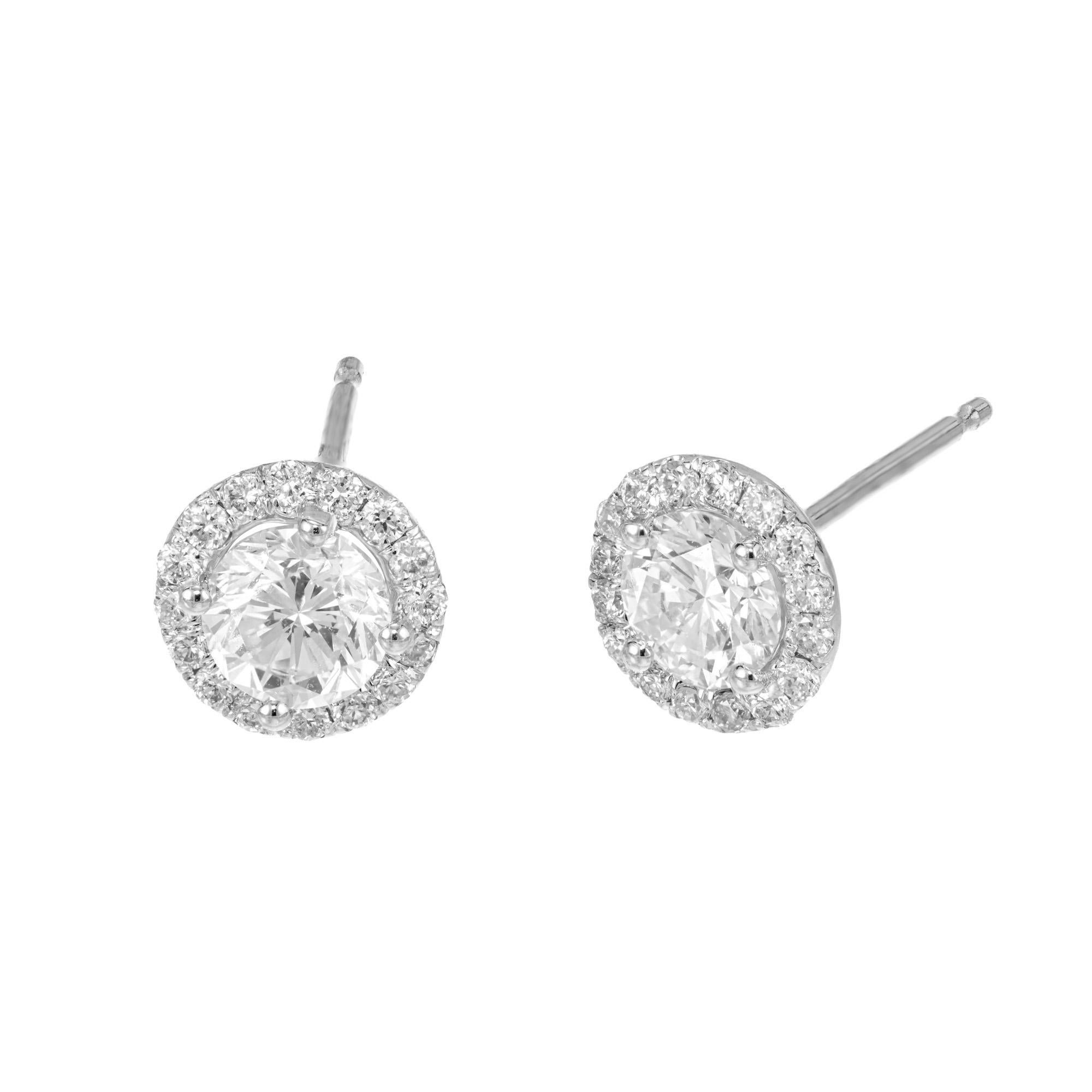 Klassische Halo-Ohrstecker mit runden Diamanten. 2 runde Diamanten im Brillantschliff in einer Fassung aus 18 Karat Weißgold mit einem Halo für runde Vollschliff-Diamanten. Diese Nieten sind ein zeitloses Design, das nie aus der Mode kommt und zu