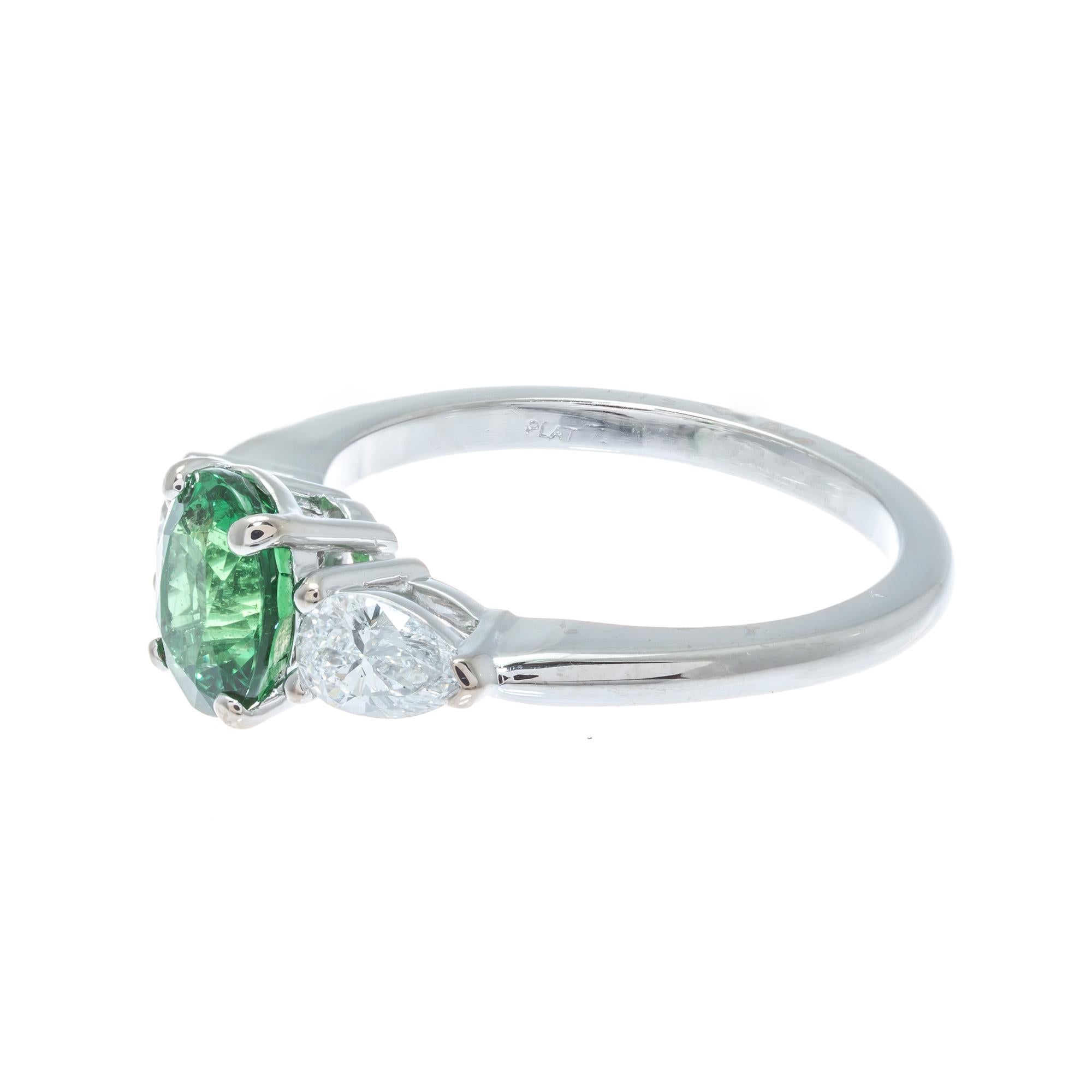 Bright green tsavorite garnet and diamond three-stone engagement ring. GIA certified natural oval tsavorite center stone with two pear shaped accent side diamonds. The platinum setting was designed in the Peter Suchy Workshop.

1 oval green SI