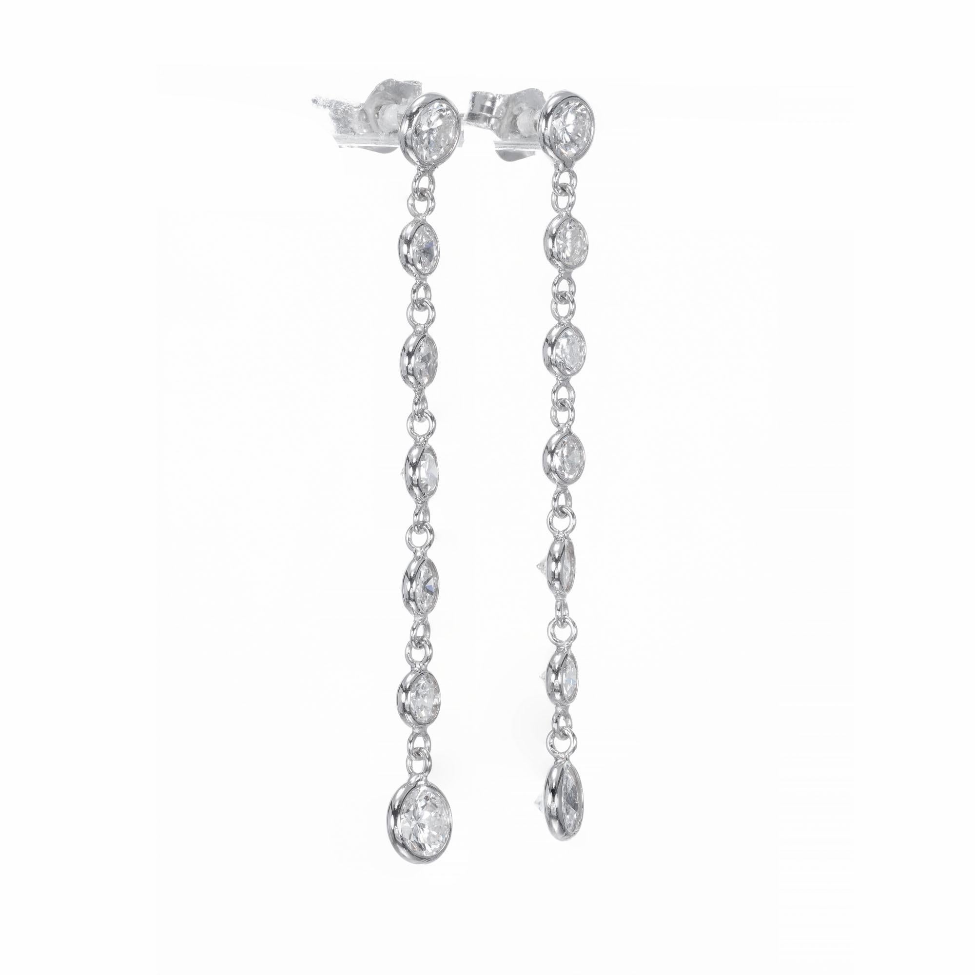 Hand crafted diamond bezel dangle drop earrings. 14 full cut diamonds in 14k white gold.  

14 full cut diamonds, G to H color, VS1 to SI1 clarity, approx. total weight 1.50cts
14k White Gold
Stamped: 14k
80 grams
Top to bottom: 1.56 inches or