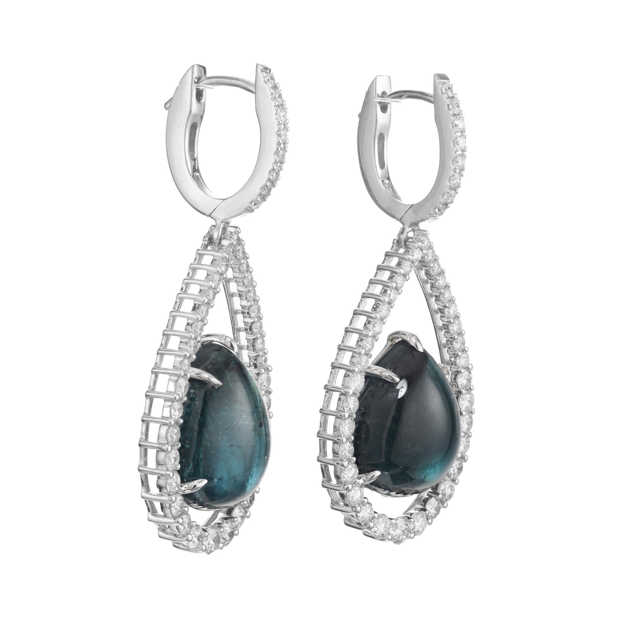 Orecchini pendenti con tormalina e diamanti. Al centro di questi pendenti ci sono 2 gemme cabochon a forma di pera di tormalina blu verdastra, per un totale di 15,84 carati. Le pietre si trovano alla base di due pendenti aperti a forma di pera in