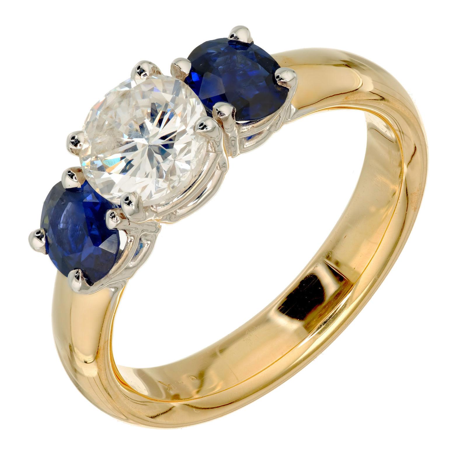 Three-Stone diamond and sapphire engagement ring. EGL certified round brilliant cut diamond, accented with two oval sapphires, in a 14k white and yellow gold setting designed in the Peter Suchy Workshop.

1 Round Brilliant Cut Diamond Approx. .86cts