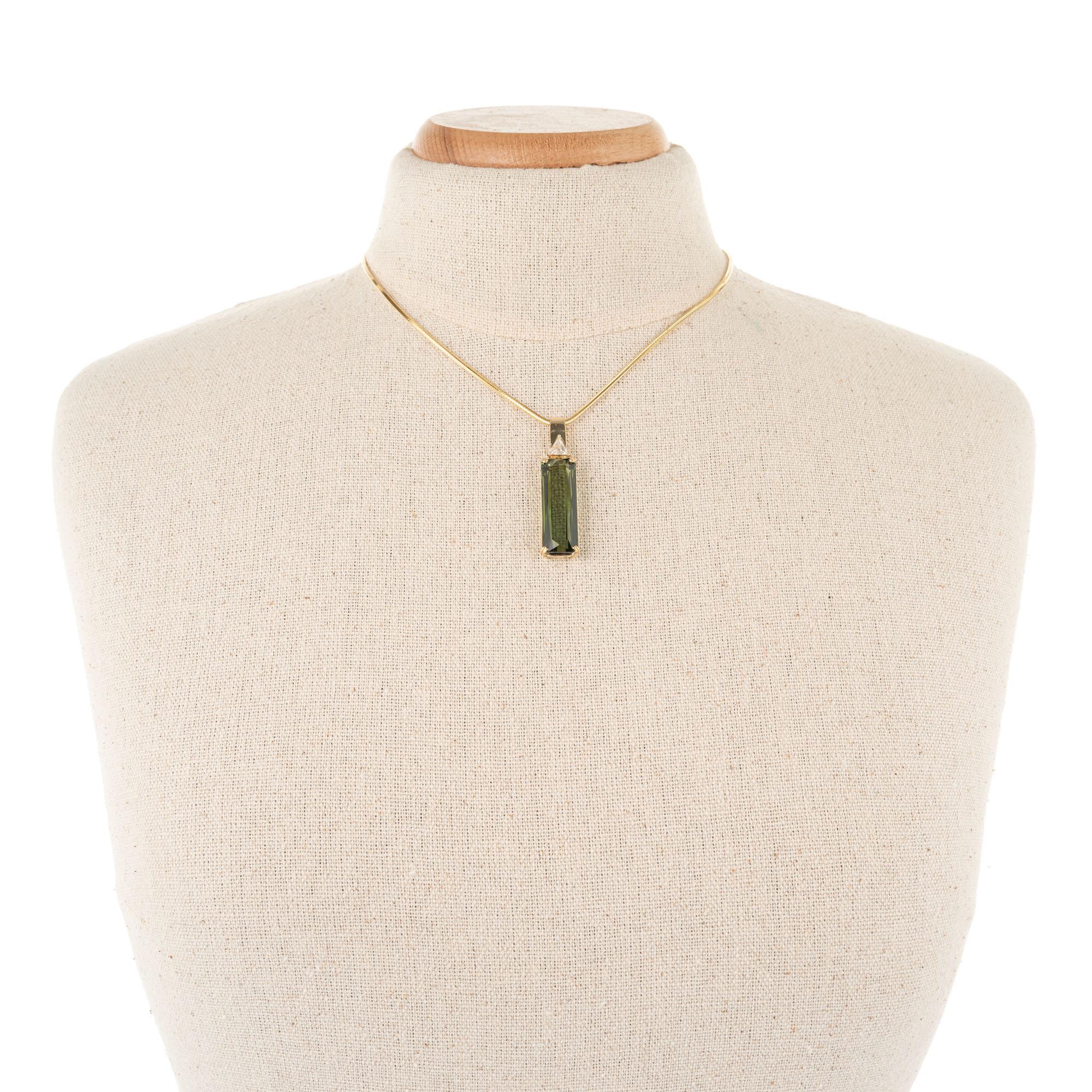Green cylinder tourmaline and trilliant cut accent diamond. 14k yellow gold pendant necklace, made in the Peter Suchy Workshop.

1 cylinder green VS tourmaline, Approximate 17.9cts
1 trilliant cut J SI2 diamond, Approximate .32cts
14k yellow