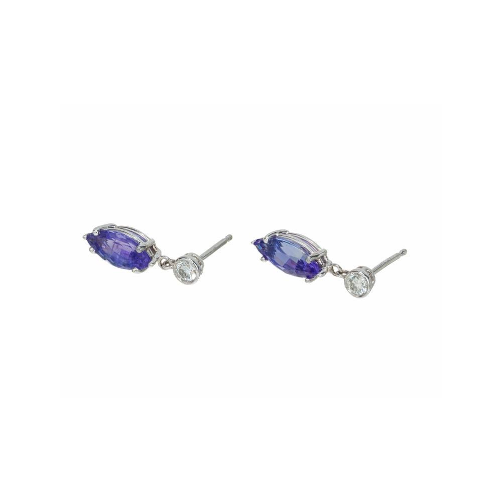 Tanzanite and diamond earrings. 2 beautiful purple and blue marquise shaped Tanzanite gemstones totaling 1.80 carats set in 14k white gold simple four prong settings. Each stone is accented with a bezel mounted round cut diamond. Designed and