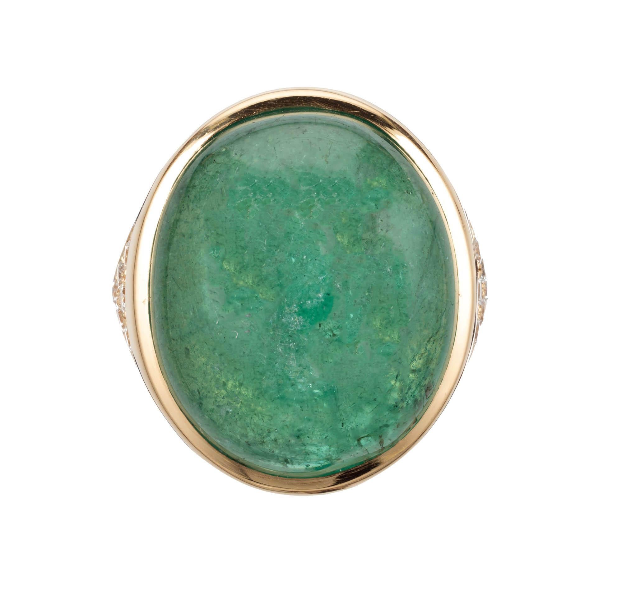 Peter Suchy oval emerald and diamond cocktail ring.  The center is set with a 21.58 carat oval cabochon emerald, accented with 6 round diamonds on each side of the 18k yellow gold setting. GIA Certified.

1 Oval cabochon green I emerald, Approximate
