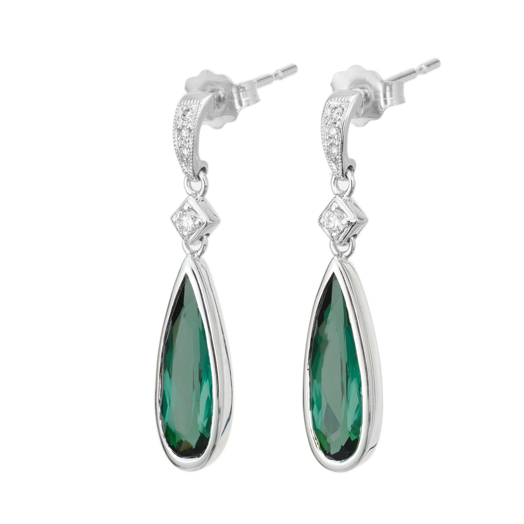 Green pear-shaped tourmaline and diamond dangle earrings. Tourmaline dangles with 8 round brilliant cut accent diamonds in 14k white gold. Designed and crafted in the Peter Suchy workshop.

2 pear shaped green tourmaline, approx. 2.17cts
8 round