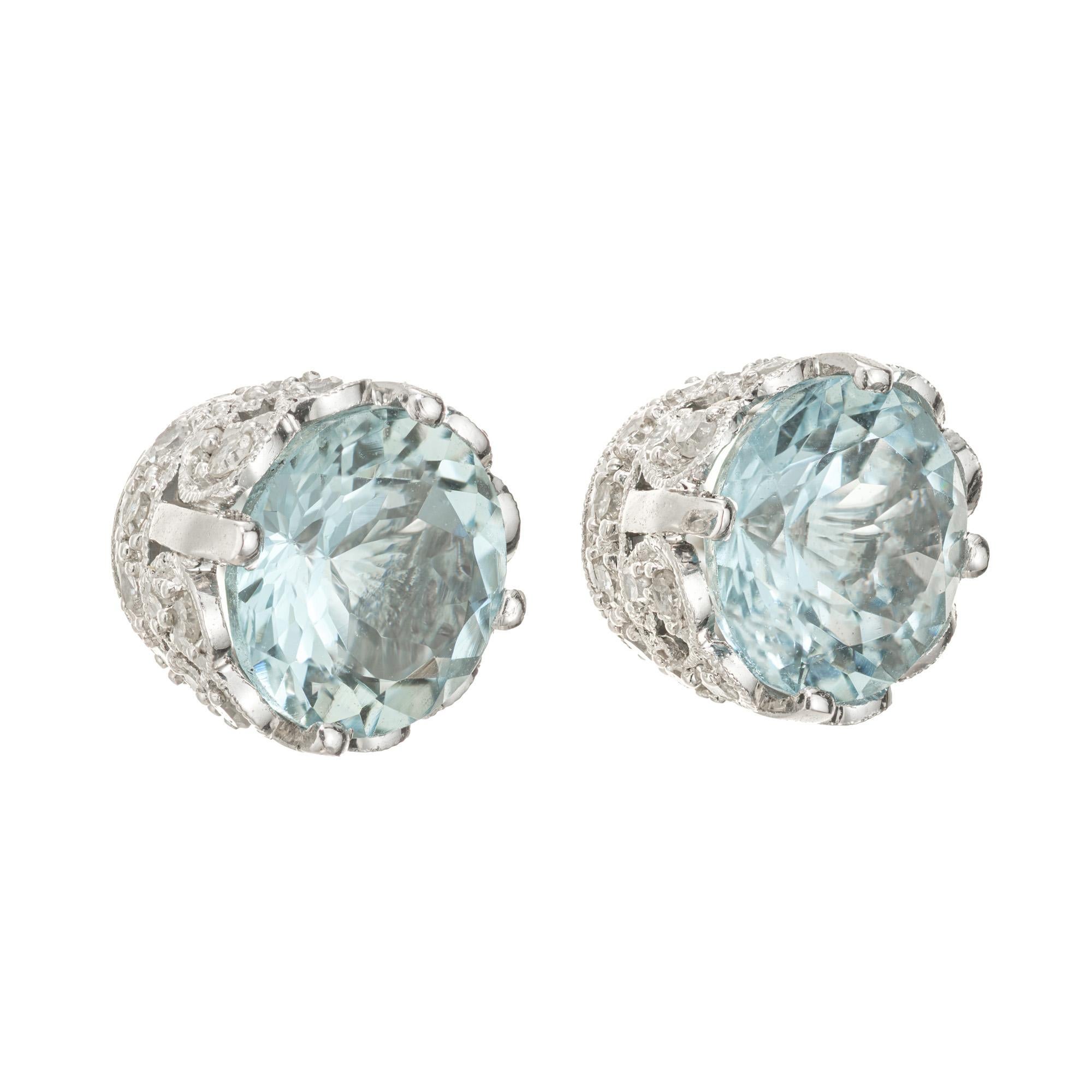 Round aqua and diamond stud earrings. 2 round blue aquamarine set in 18k white gold basket settings each with 34 round cut accent diamonds. Vintage Art Deco inspired with screw back posts. Designed and crafted in the Peter Suchy Workshop

2 round