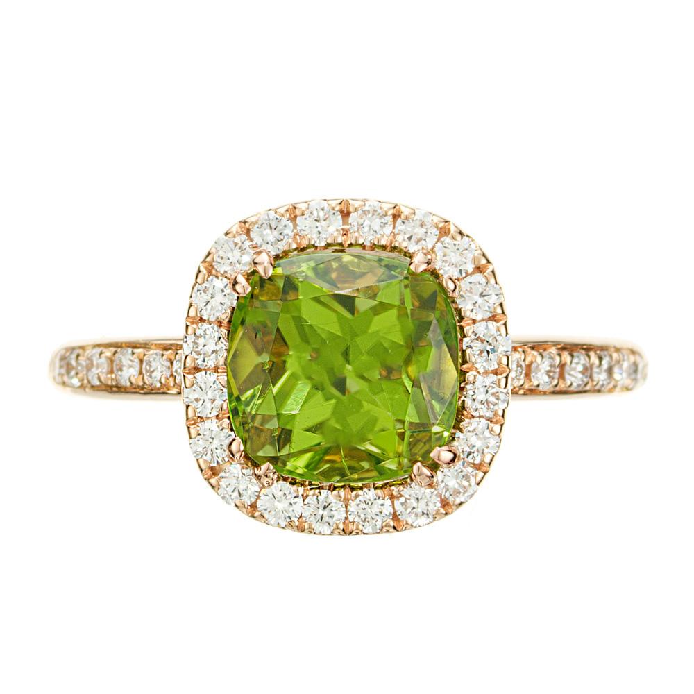 Peridot and diamond engagement ring. 2.63 cushion cut green Peridot center stone, in an 18k rose gold setting with a halo of diamonds, accented with diamonds on each side of the shank. Designed and crafted in the Peter Suchy Workshop.

1 cushion cut
