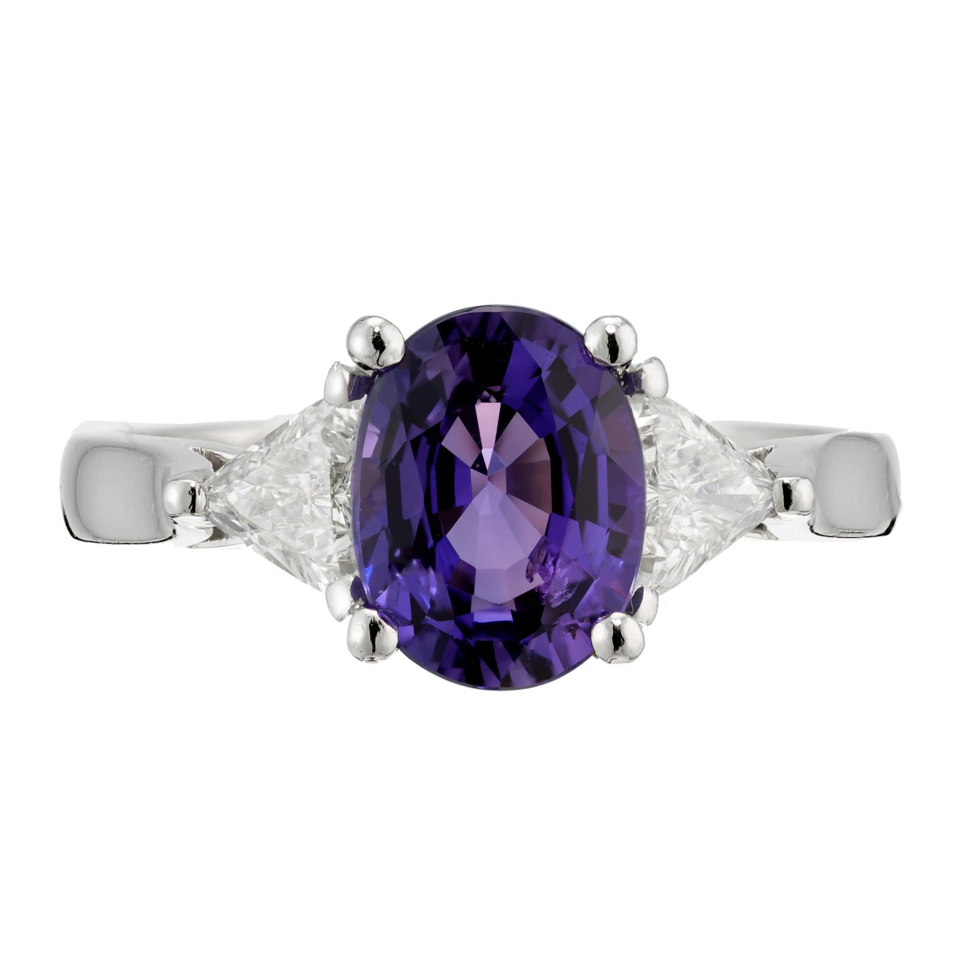 Purple sapphire and diamond engagement ring. AGL certified 2.65cts oval center stone, set in a platinum three-stone setting with two trilliant cut side diamonds.  Sapphire is certified as natural, no heat . Violet purple sapphire. The stone is Circa