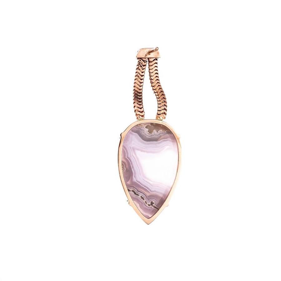 Discover the captivating allure of our Peter Suchy 27.35ct pear Agate rose gold dangle earrings, where elegance meets artistry in a breathtaking piece. 2 naturally purple pink Agate stones mounted in 14k rose gold frames that suspend from double