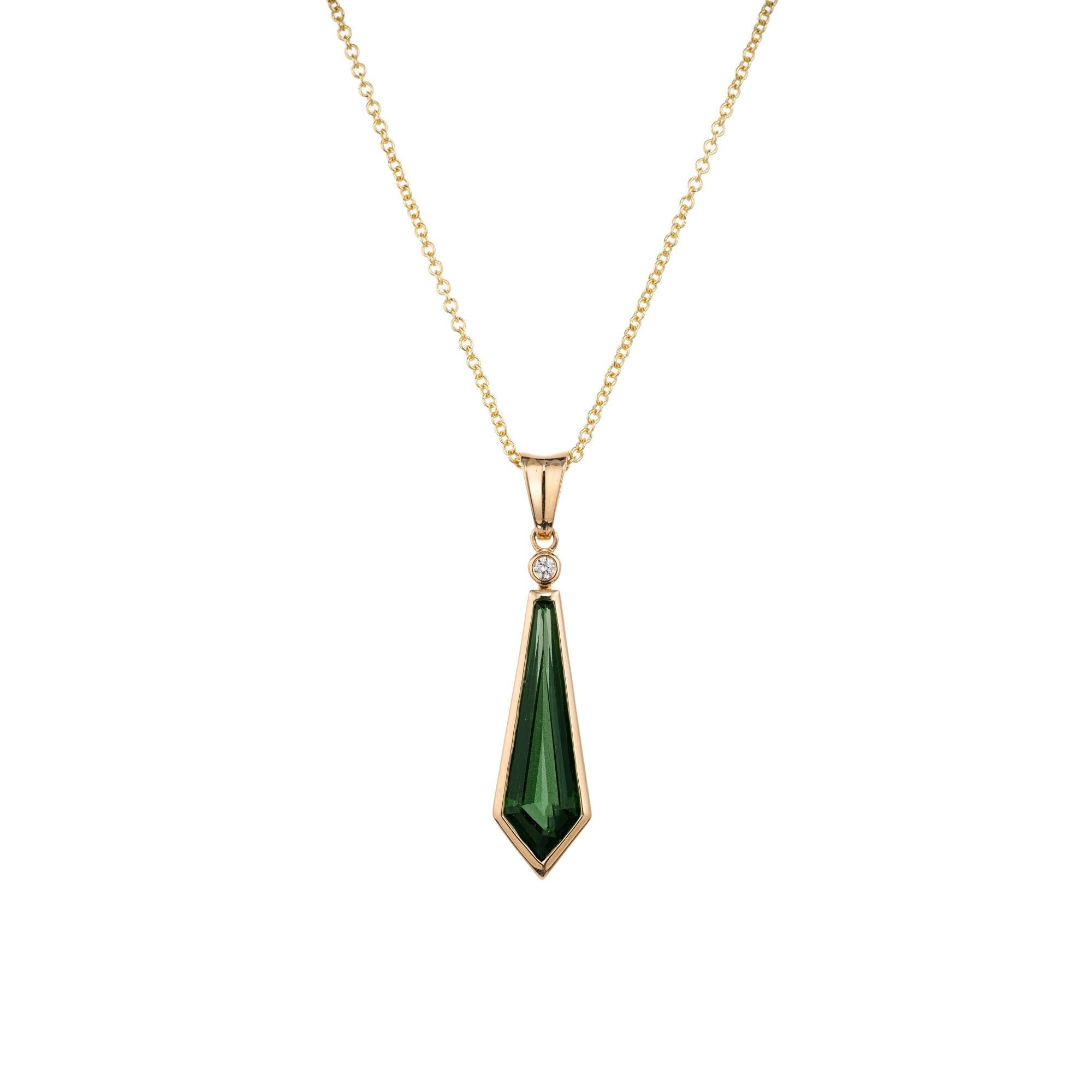 This pendant is a bright green kite shaped tourmaline diamond necklace set in a 14k yellow gold frame with a bezel set diamond on top. The tourmaline is 2.87 carats while the round diamond above it is .03cts, making a compelling timeless design that