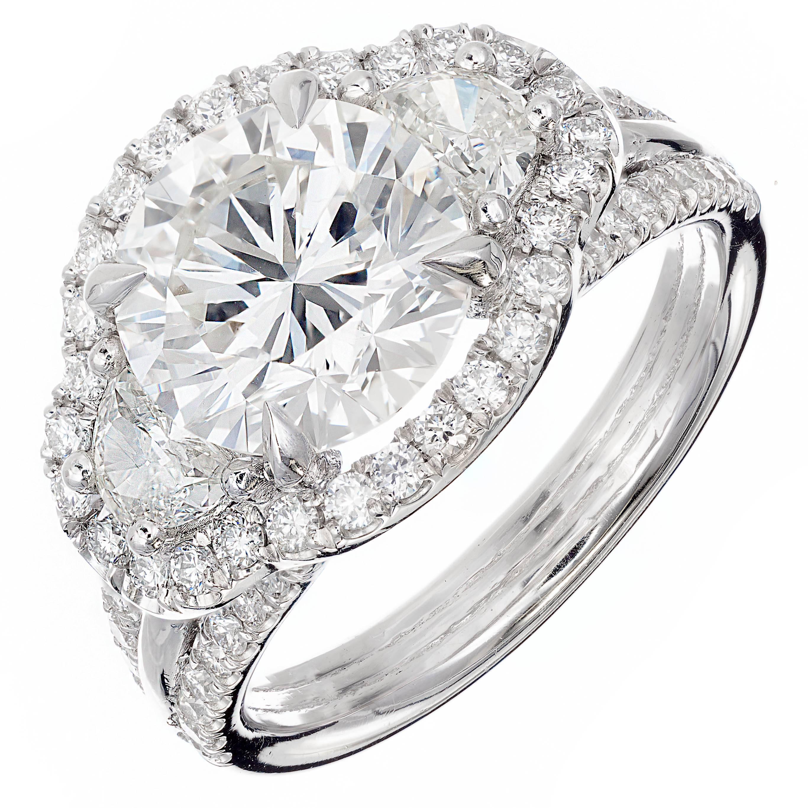 GIA certified Ideal cut bright white diamond three-stone engagement ring. Round brilliant center stone accented with two half-moon side diamonds and full cut all around Halo rim, on a custom split shank setting. From the Peter Suchy Workshop. 

1