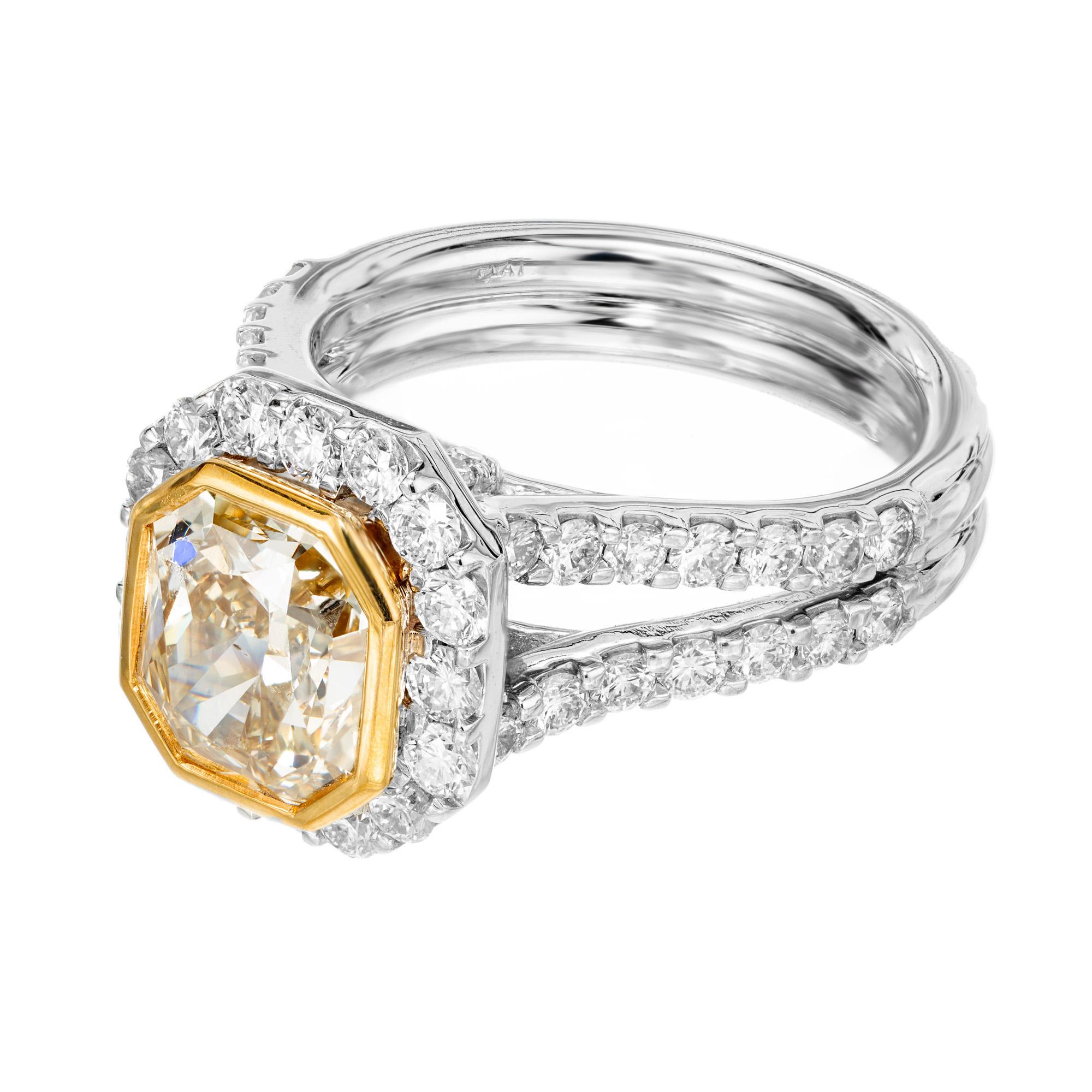 Spectaculaire bague de fiançailles en diamant jaune doré naturel. Magnifique diamant central certifié GIA de 3,03ct à taille radiante monté dans une monture à deux branches en platine avec un chaton en or jaune 18k et un halo de diamants. Elle est