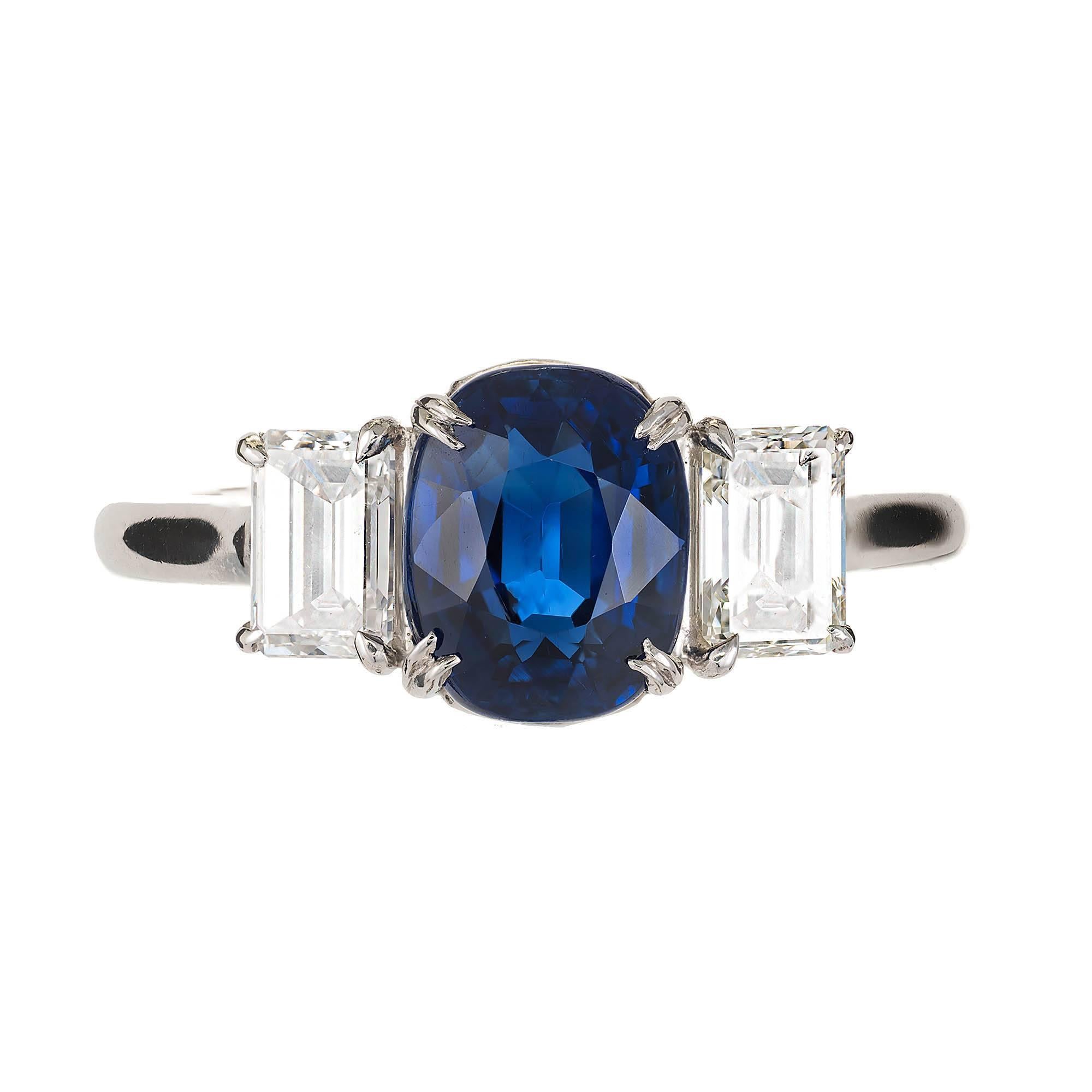Sapphire and diamond three-stone engagement ring. Cushion cut  3.11ct center sapphire Sapphire, pure deep bright blue from deep inside, accented with two emerald cut diamonds in a platinum setting designed by the Peter Suchy Workshop. GIA certified
