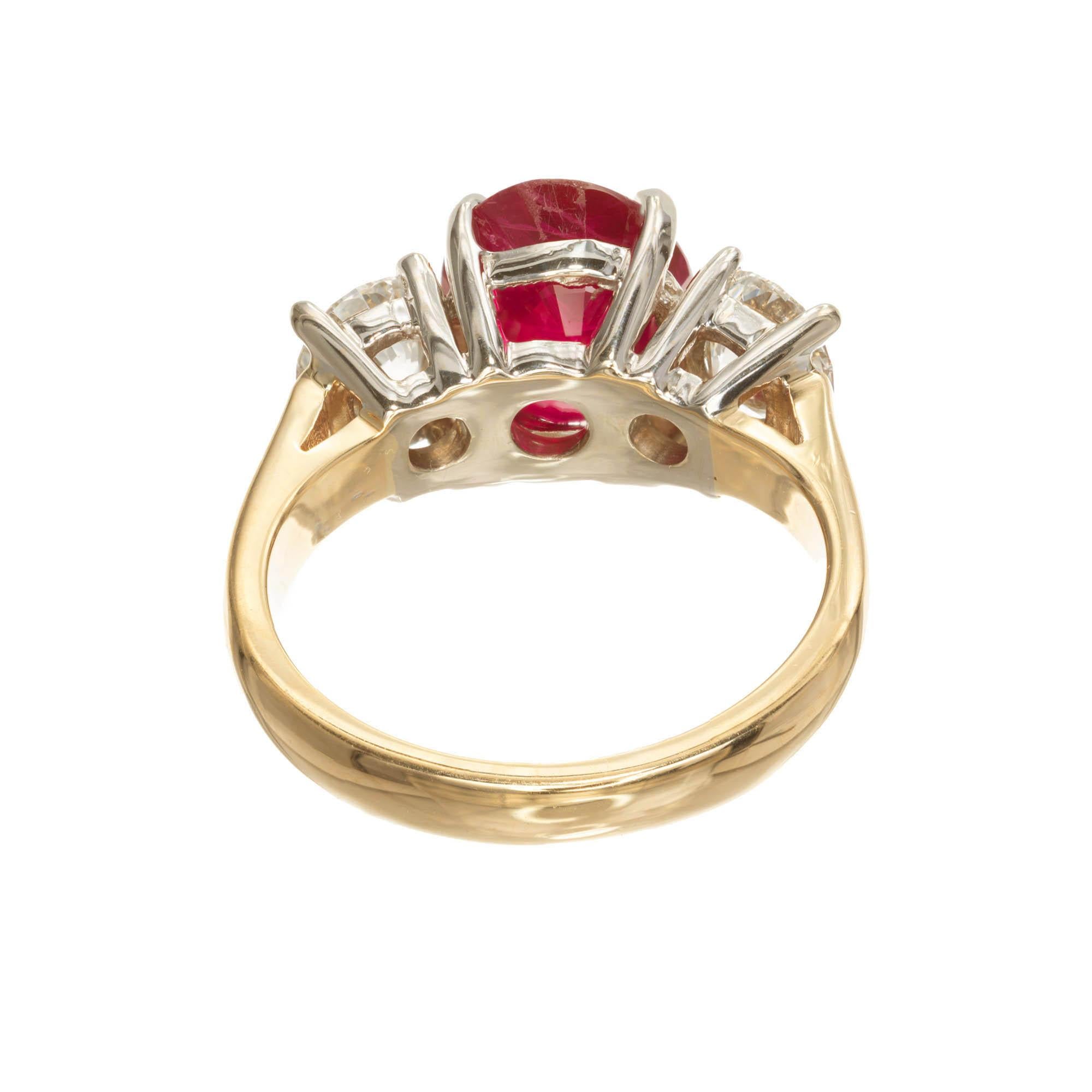 Peter Suchy ruby and diamond three-stone engagement ring.  AGL Certified natural Burma ruby 3.16 carats. Simple heat minor clarity enhancement. Two bright sparkly round diamonds 1.12 carats total. in a two-tone 14k yellow gold.

1 oval red SI ruby