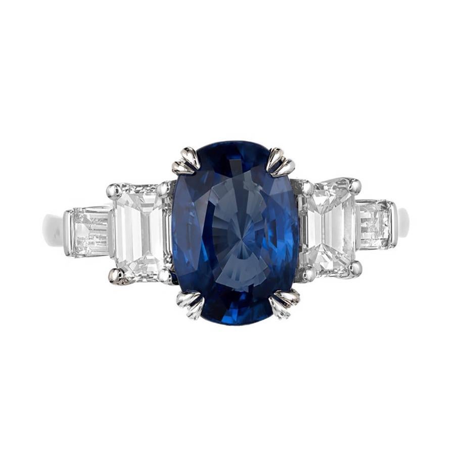 Zafiro azul brillante natural sin calor de Sri Lanka en un anillo de compromiso de platino de tres piedras hecho a mano. Dos diamantes baguette laterales. Del taller de Peter Suchy. 

1 Zafiro ovalado azul brillante gema superior, peso total aprox.