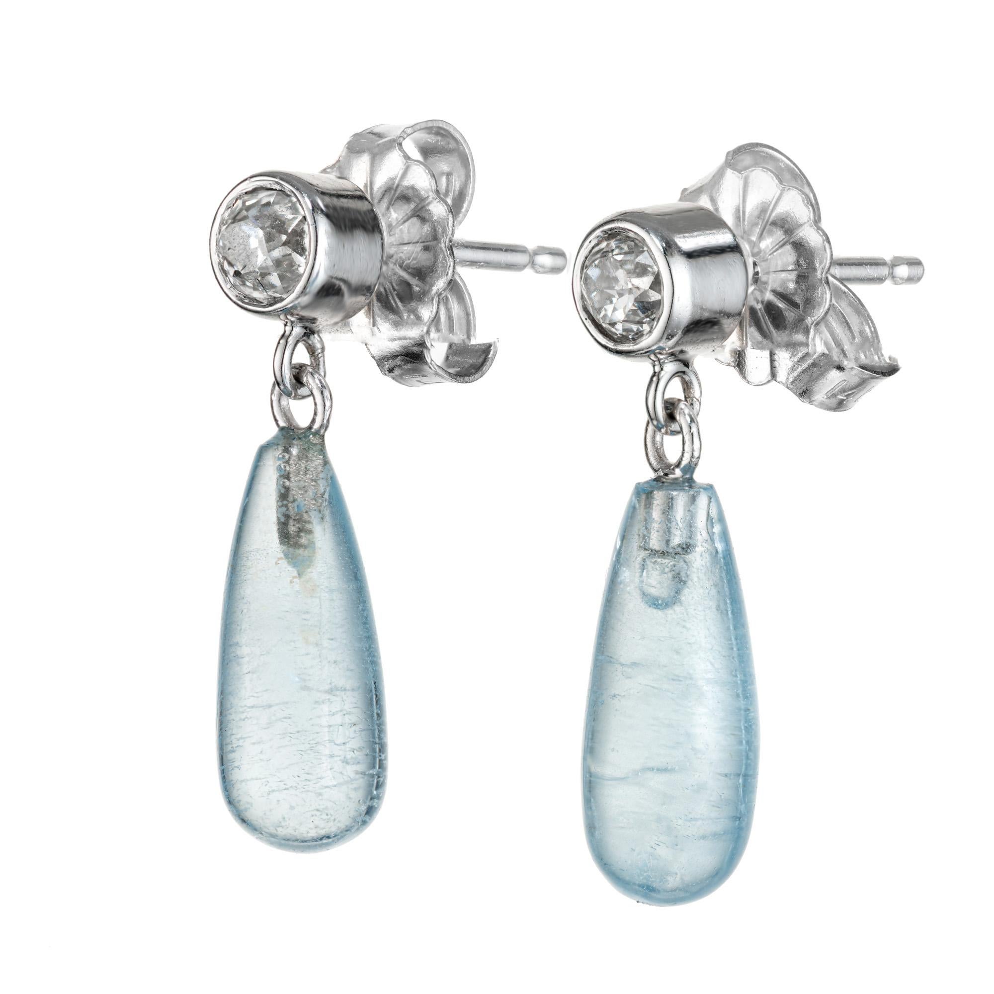 Natural untreated aqua cylinder dangle and diamond earrings. 2 tapered cylinder cut Aquamarine dangles with 2 old mine cut bezel set diamond tops. 14k white gold. Designed and crafted in the Peter Suchy workshop

2 tapered cylinder cut blue aquas,