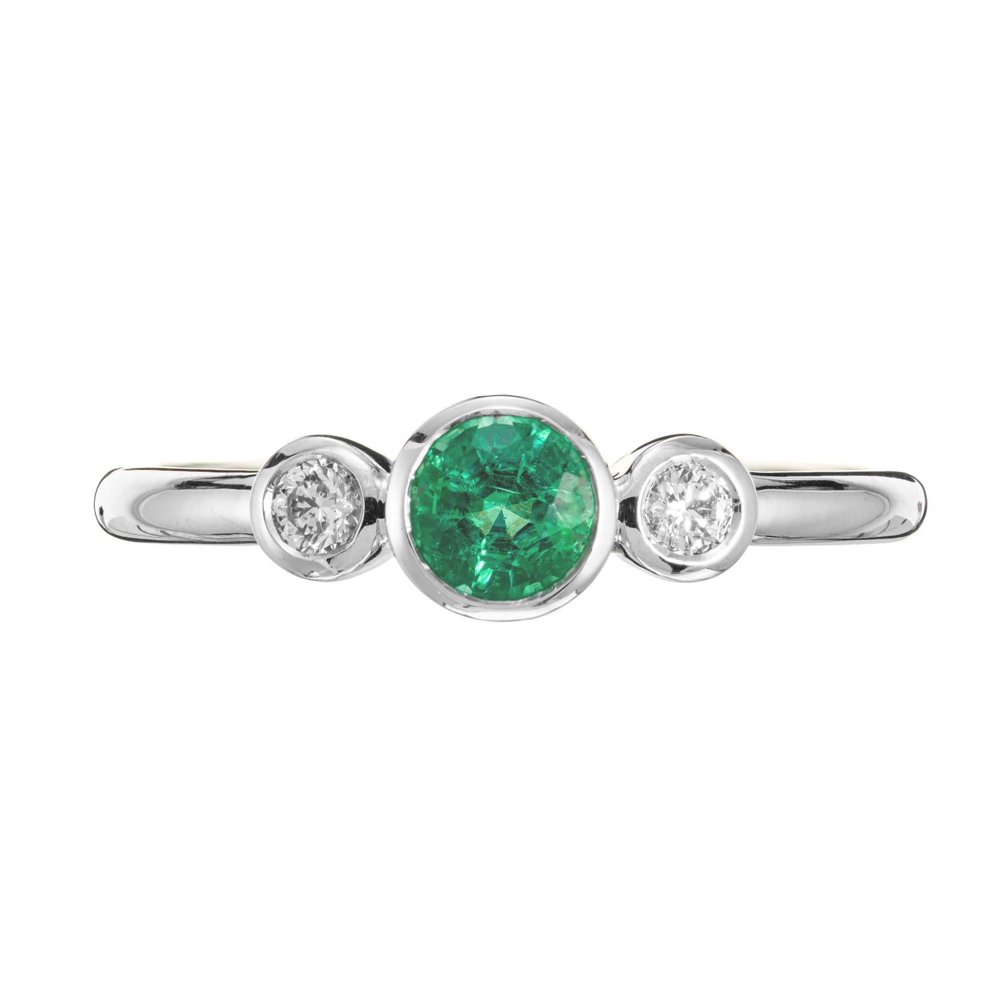 Emerald diamond gold engagement ring. .39ct round bezel set emerald with 2 round side diamonds in a 18k white gold setting. Designed and crafted in the Peter Suchy workshop.

1 round green emerald, approx. .39cts
2 round diamonds, H-I SI approx.