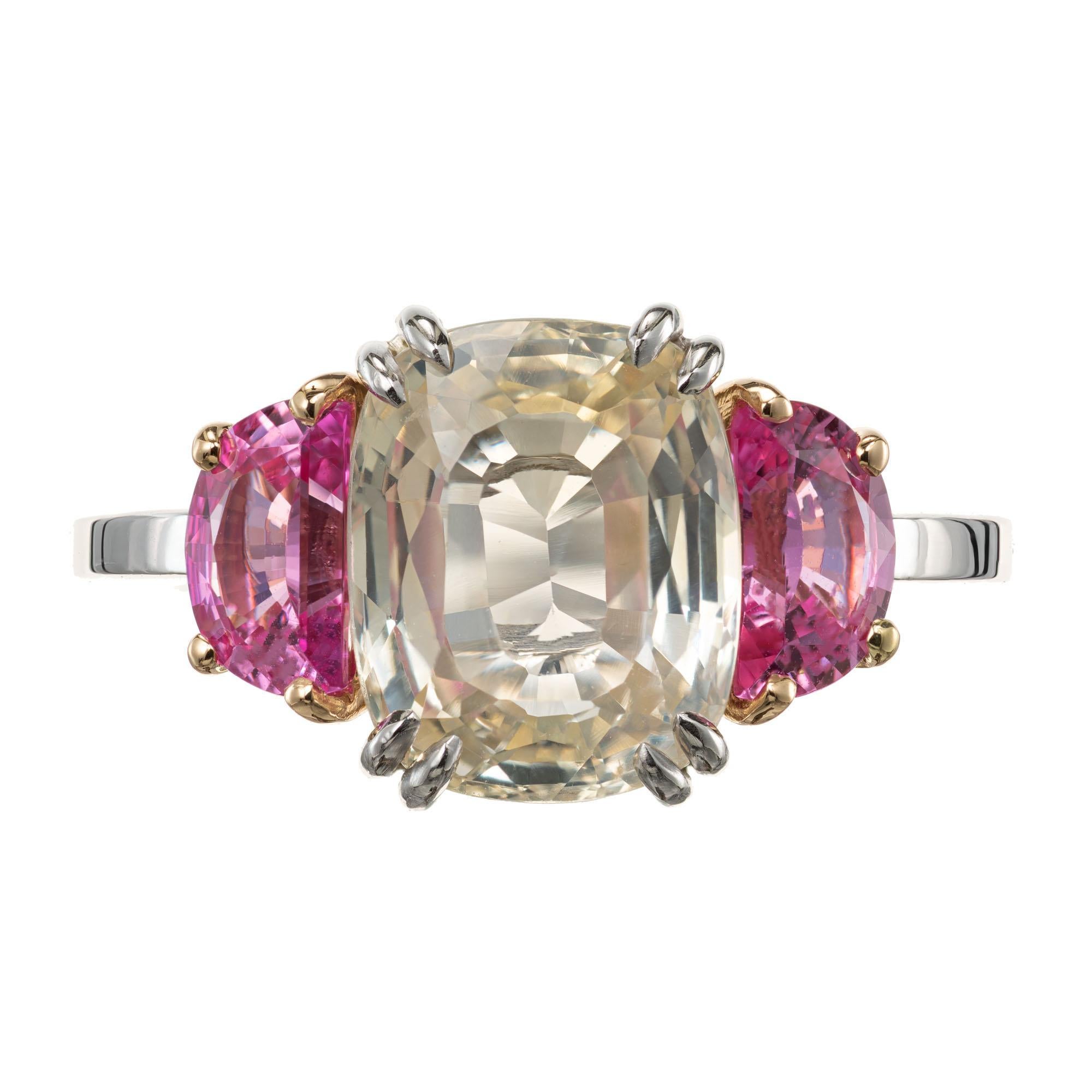 Cushion cut light yellow sapphire and two bright pink half moon sapphires. 3.91ct sapphire center stone, with tow pink sapphire accent diamonds in a three-stone engagement ring setting created by the Peter Suchy Workshop

1 cushion cut light yellow